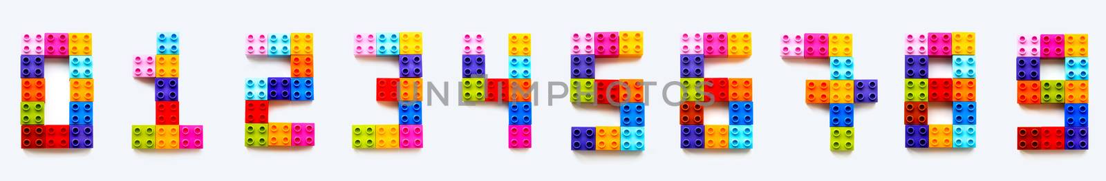 Set of numbers from 0 to 9 made of colorful constructor blocks. Toy bricks lying in order from zero to nine. Education process - learning numbers with child using multicolored toy details.