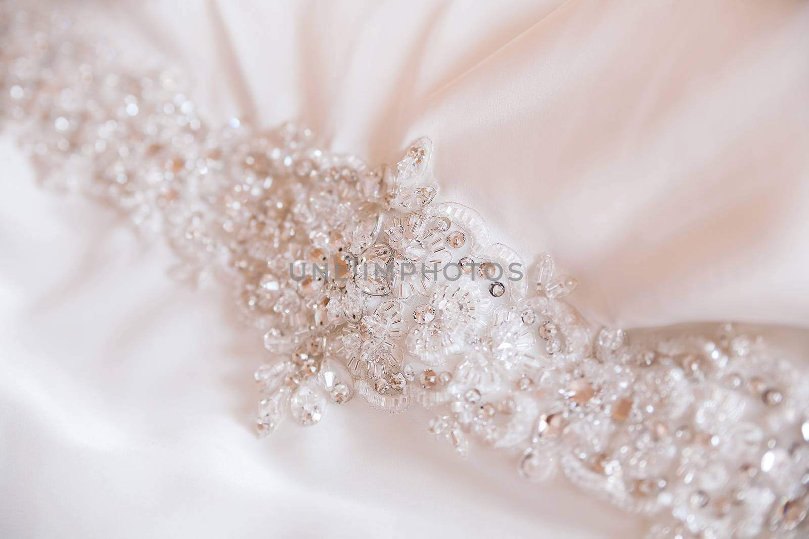 Bead embroidery on silk wedding dress. Waist of dress embroidered with beads.