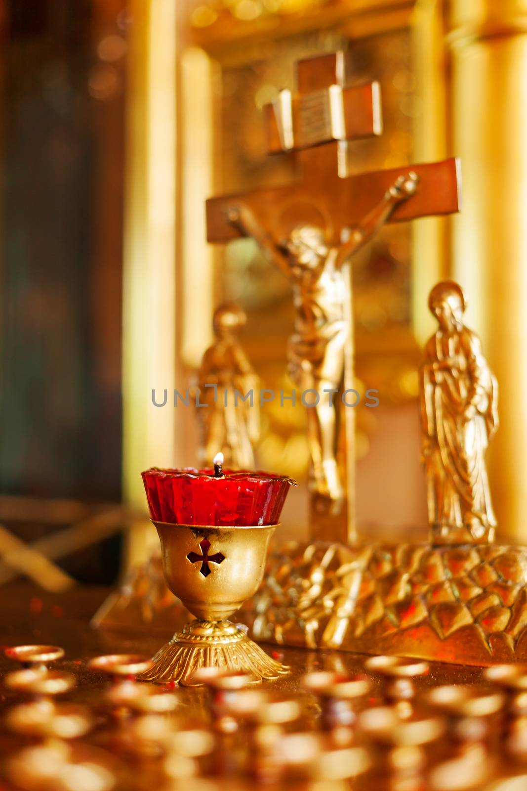 Golden candleholder in Orthodox church. Symbolic Orthodox gold cross with the crucifixion of Jesus. by aksenovko