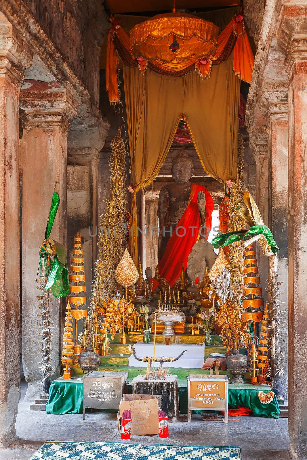 Room with scented candles, Buddha sculpture and sacral decorations in Angkor Wat, a temple complex in Cambodia and the largest religious monument in the world. UNESCO World Heritage Site.