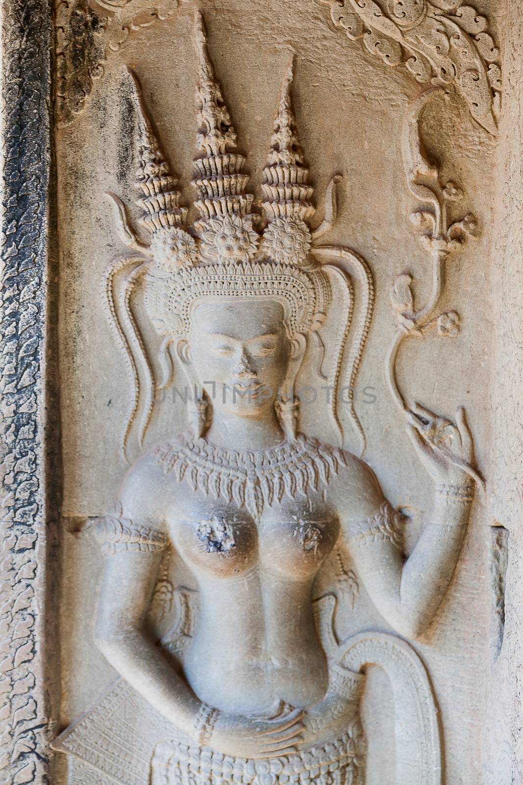 Apsara dancers carved in stone, all around on the walls at Angkor Wat (largest religious temple complex monument in the world). Siem Reap, Cambodia. UNESCO World Heritage Site. by aksenovko