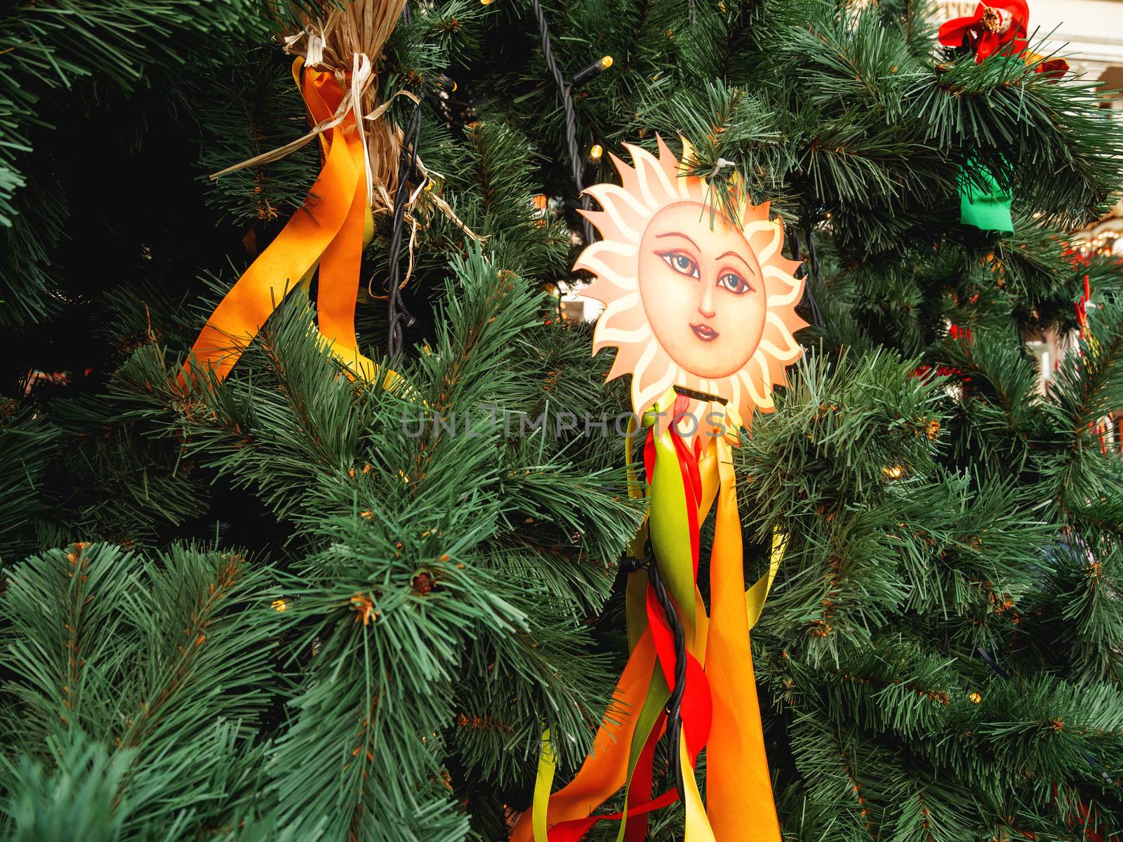 Maslenitsa celebration. Fir tree decorated with sun symbols and colorful ribbons. Moscow, Russia.