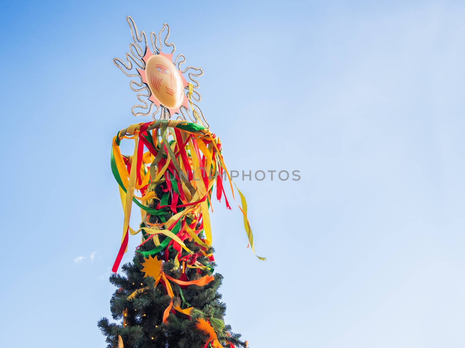 Maslenitsa celebration. Fir tree decorated with sun symbols and colorful ribbons. Moscow, Russia.