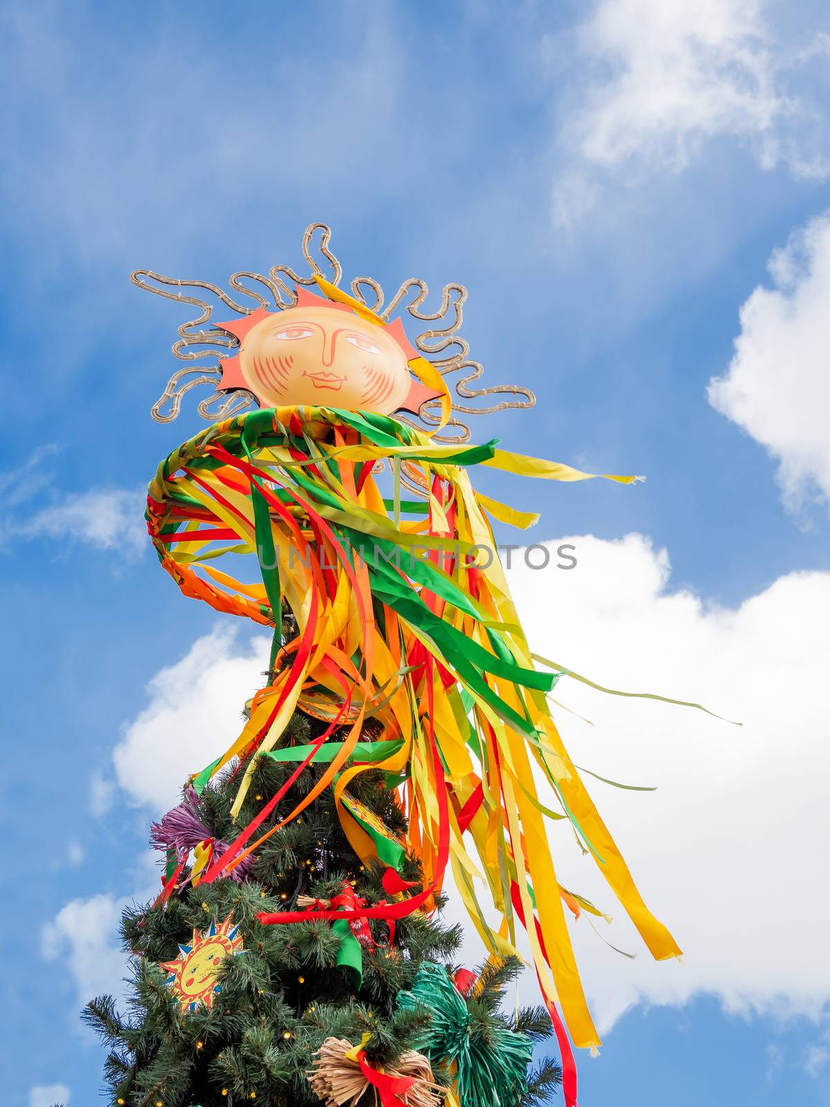 Maslenitsa celebration. Fir tree decorated with sun symbols and colorful ribbons. Moscow, Russia.