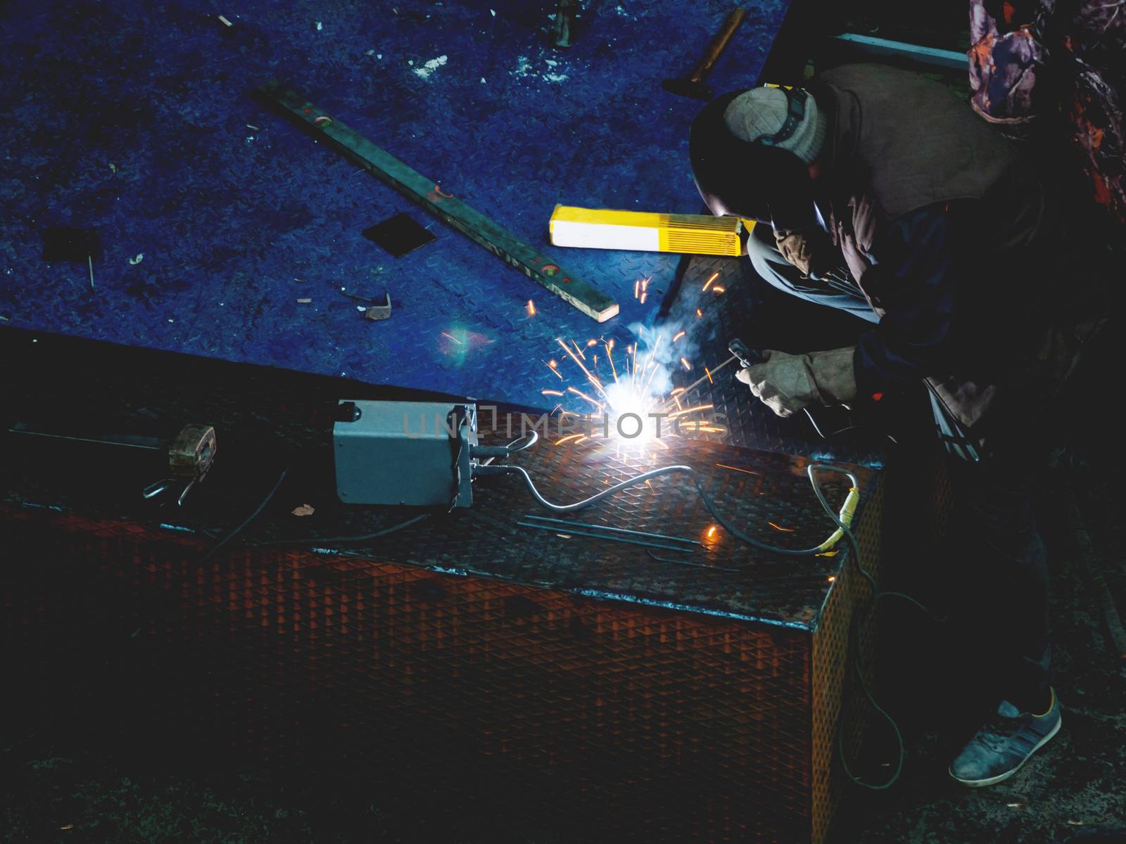 Metal welding. Worker in a welding mask repairs metal steps.
