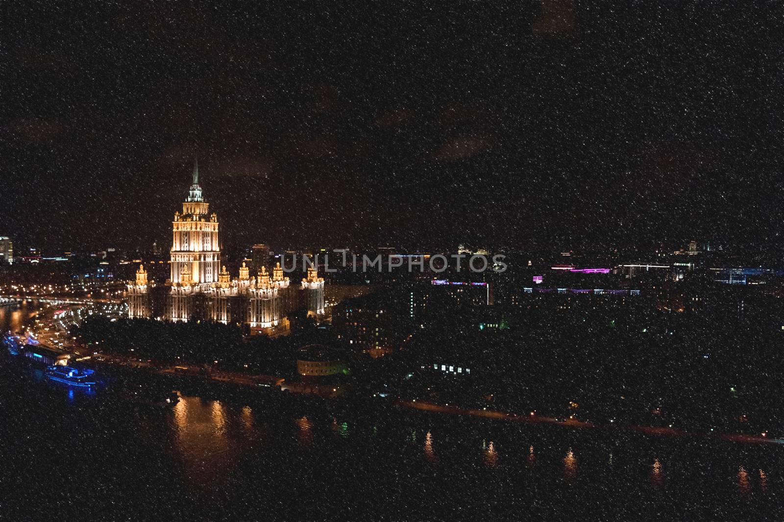 Hotel Ukraine, landmark near historic center of Moscow. Cityscape in snowy winter evening. Panoram view on city at night.