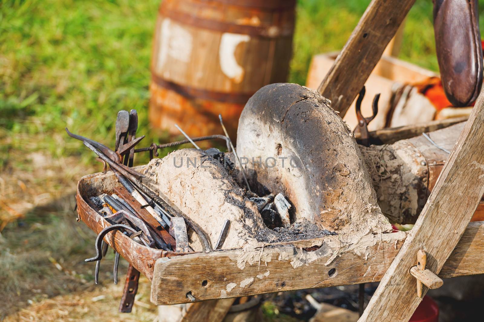 Iron old fashioned tools on portable forge. Old furnace and bellows. Historical reconstruction of 19 century.