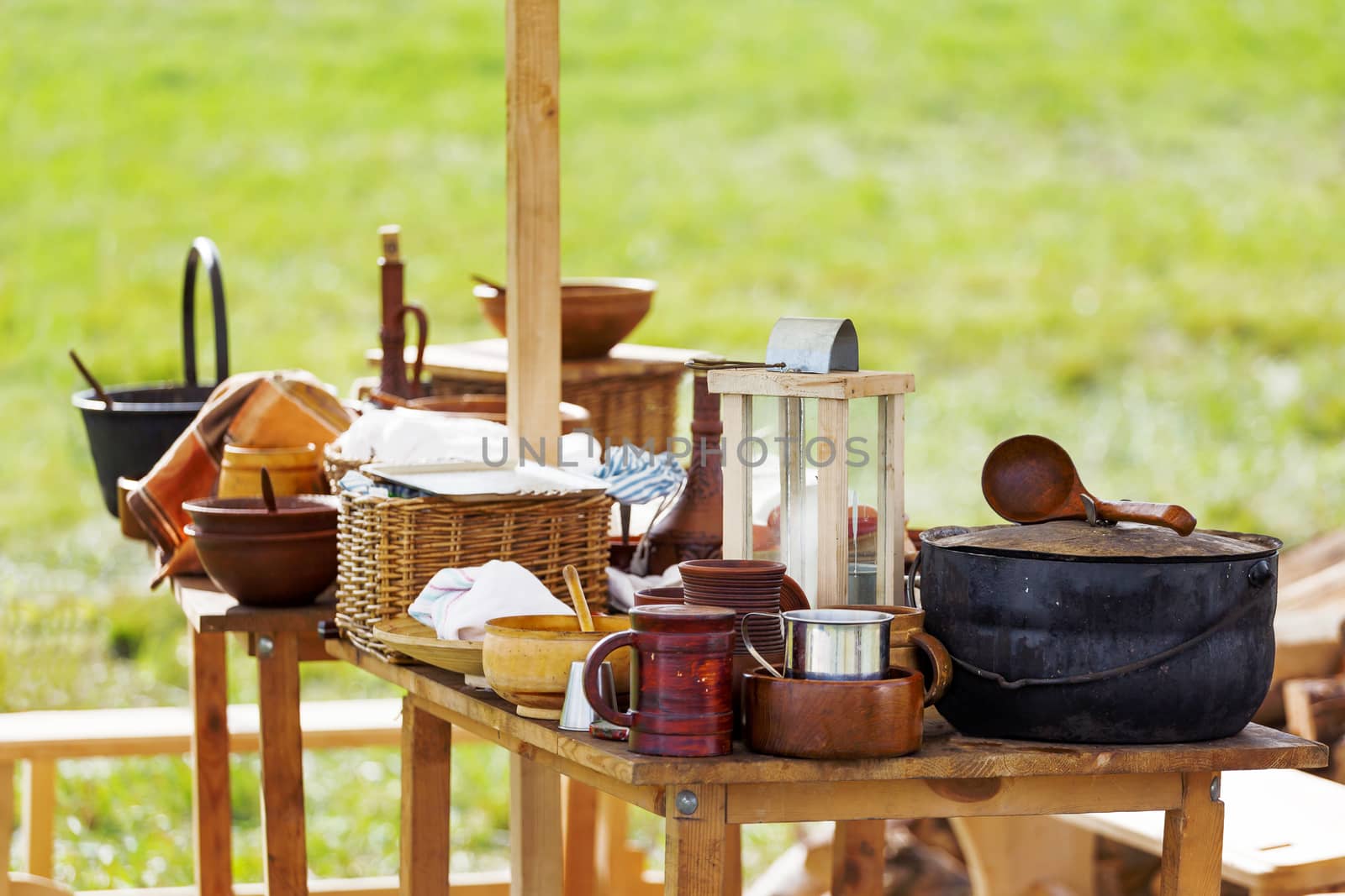 Wooden table with old fashioned wooden and earthenware crockery. Historical reconstruction of 19 century.