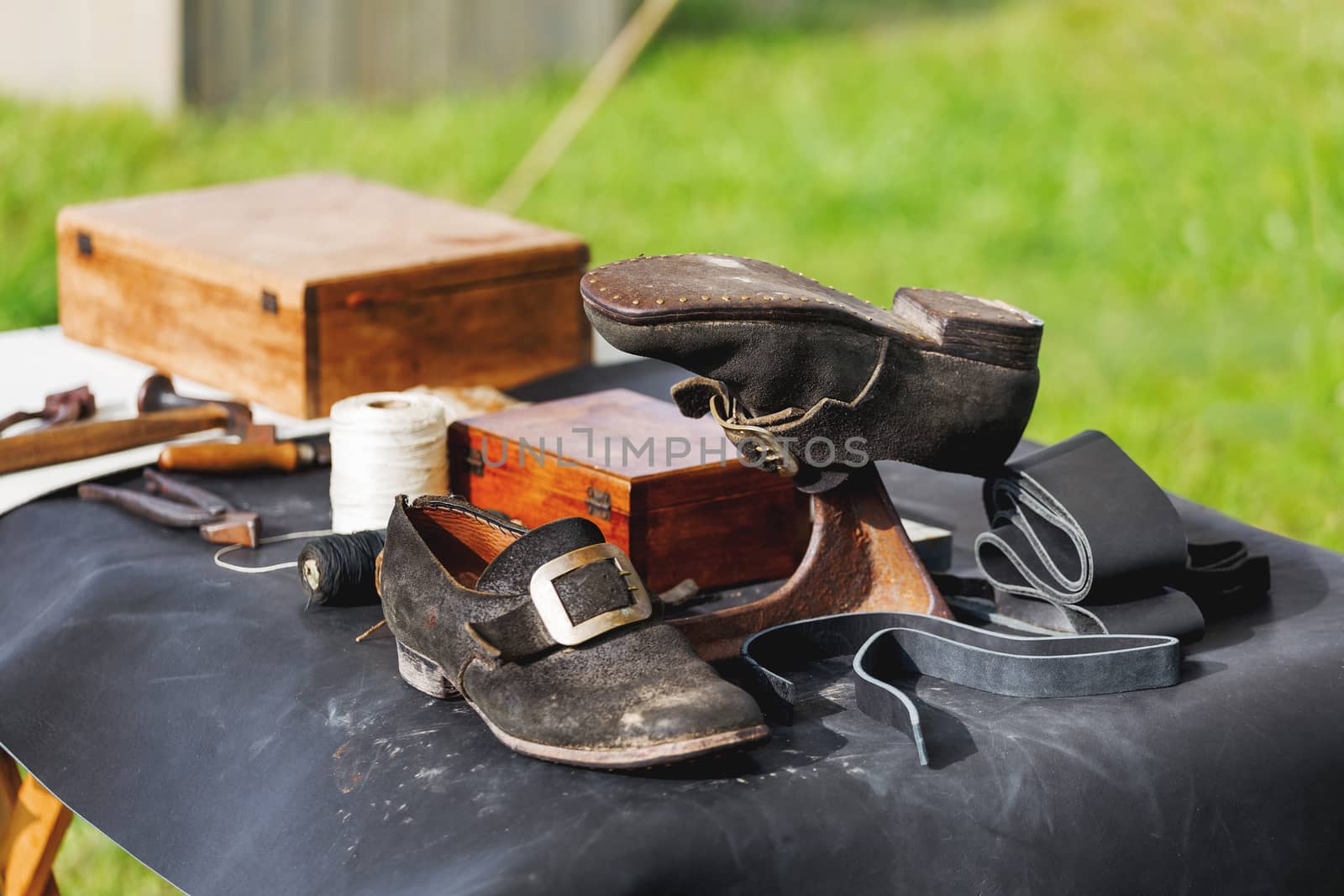 Old fashioned shoemaker set - shoes, spools of thread, tools, workpieces. Historical reconstruction of 19 centure.