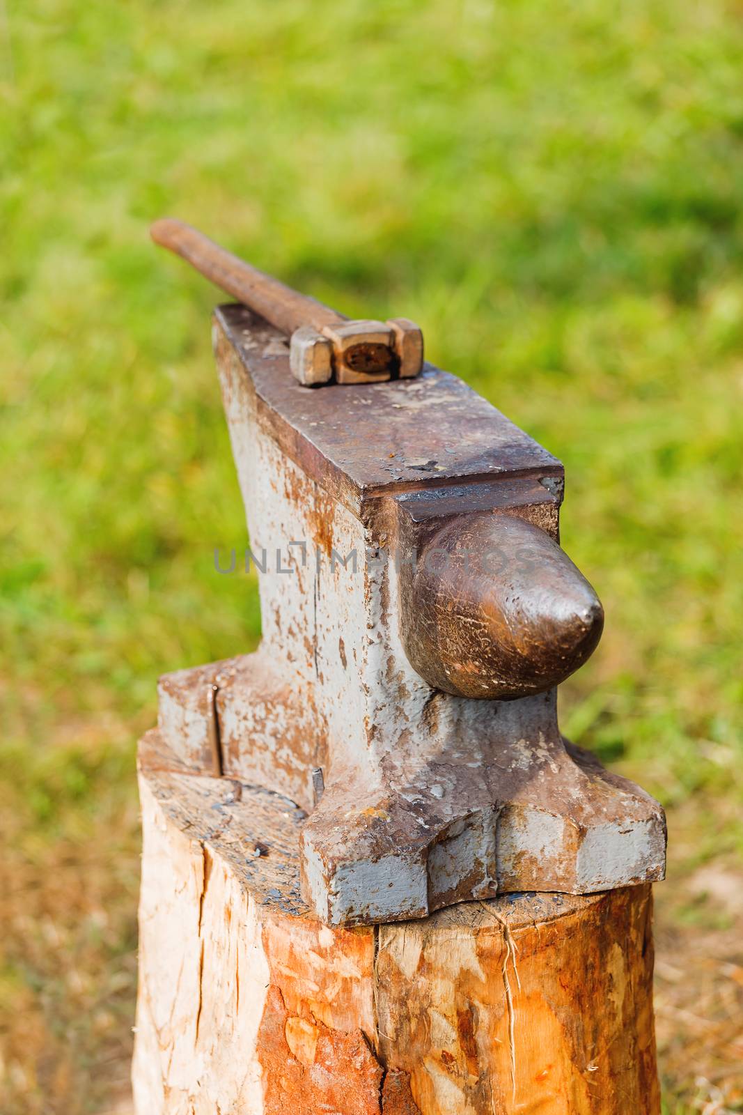 Hammer on the portable anvil. Old fashioned blacksmith tools in forge. Historical reconstruction of 19 century.