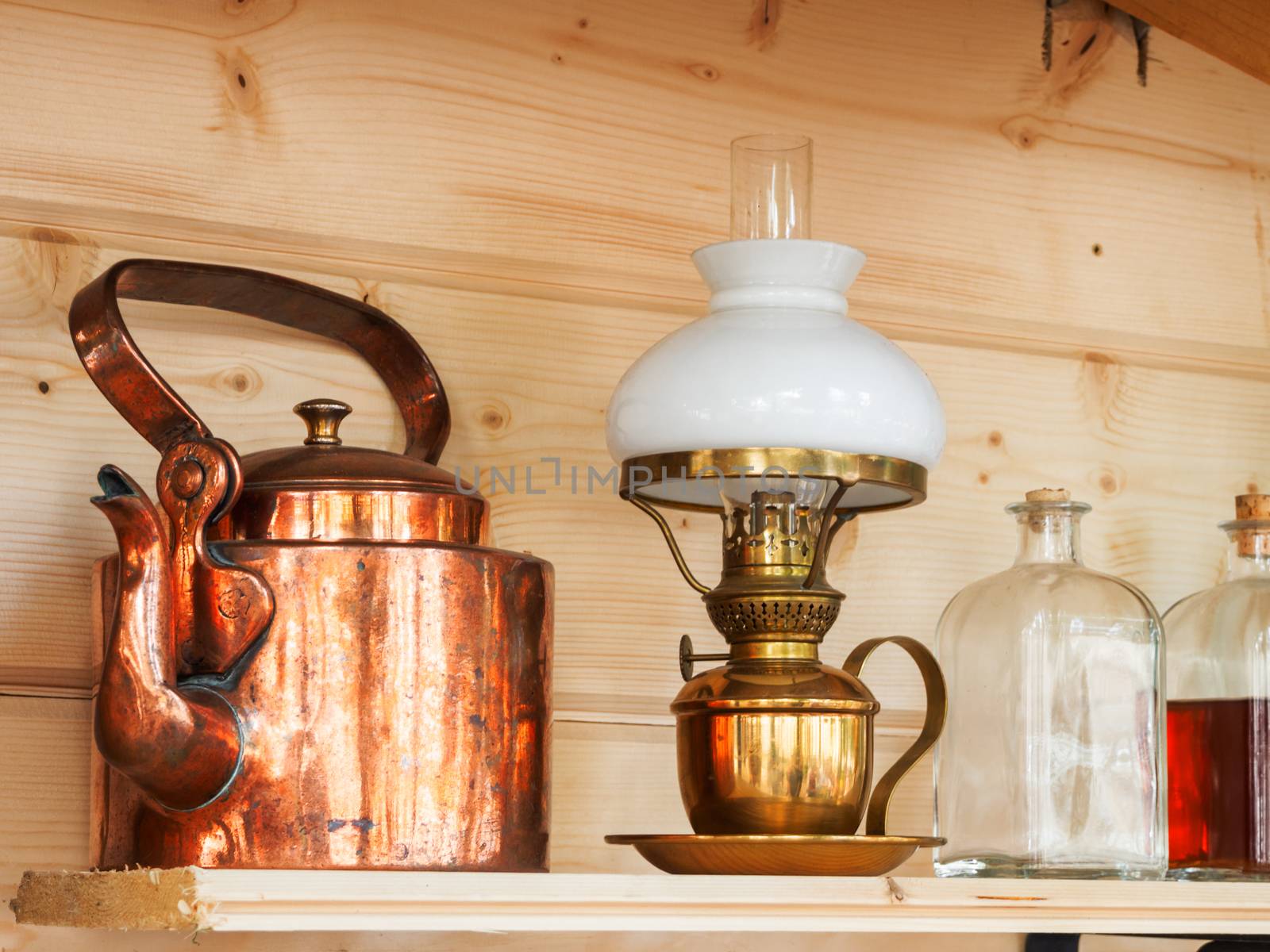 Vintage household items - copper teapot, table lamp, glass bottles with stoppers.