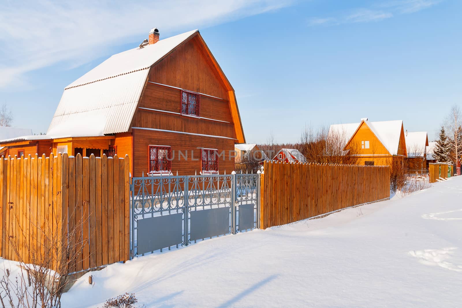 Cottage settlement. Street of wooden country houses. Winter sunny day. Russia.