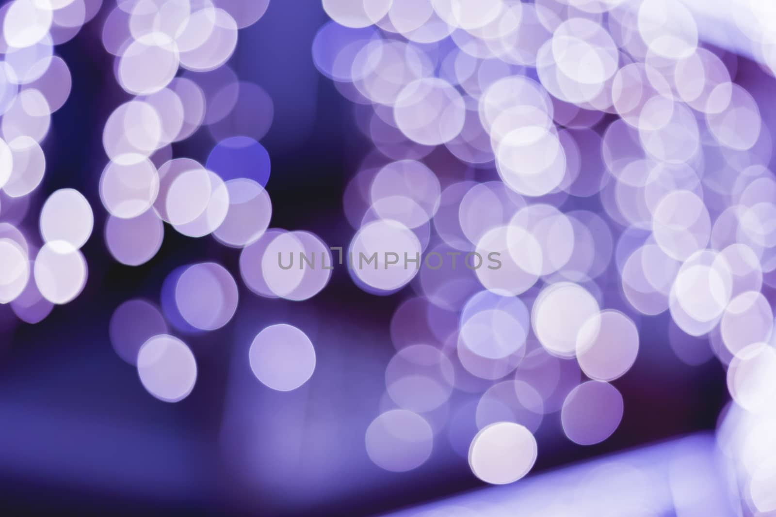 Defocused night street lights, blurred colorful bokeh background. Holiday colorful lanterns and light bulbs garlands.