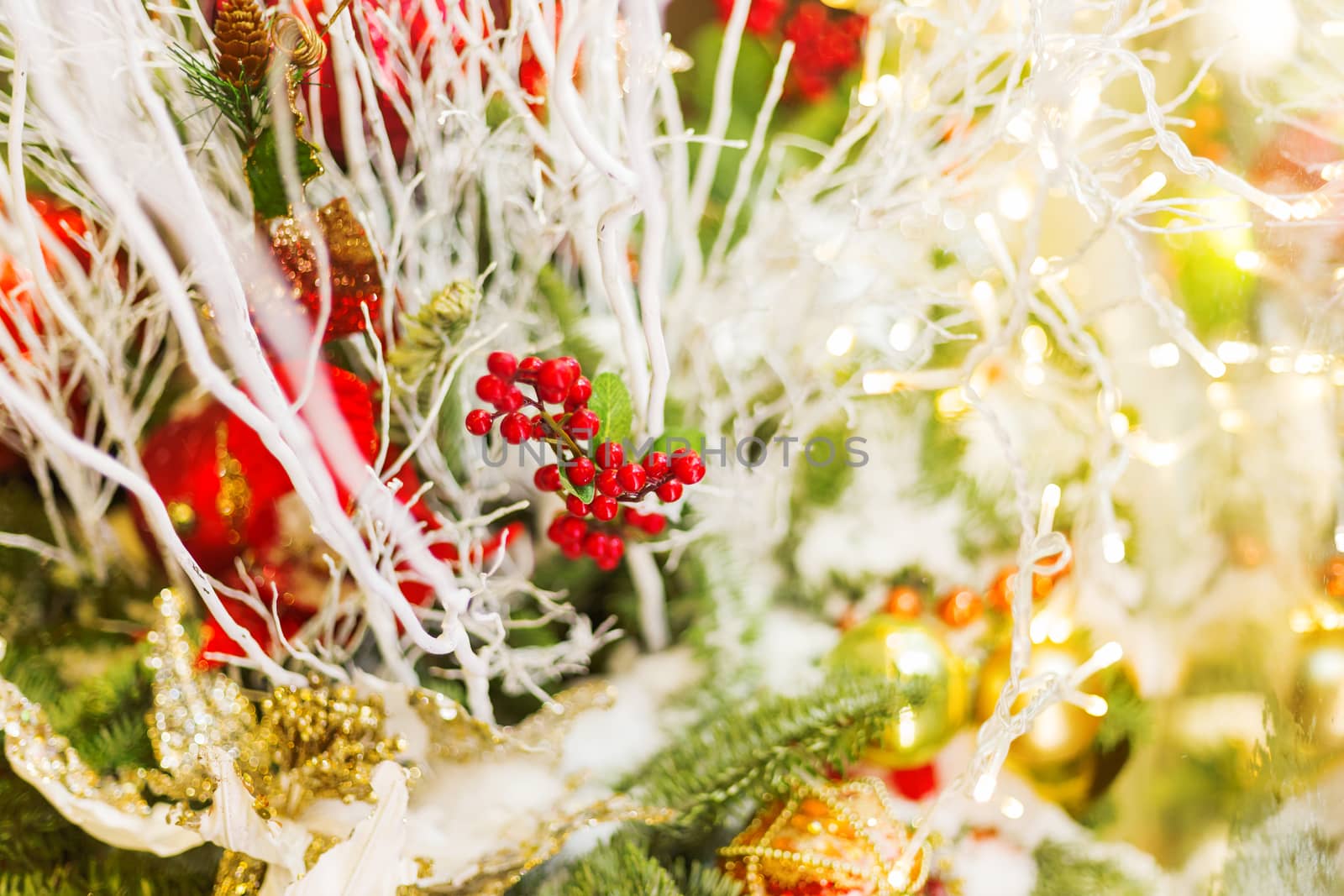 Christmas and New Year background with fir tree branches and decorations - light bulbs, berries, golden snowflakes.