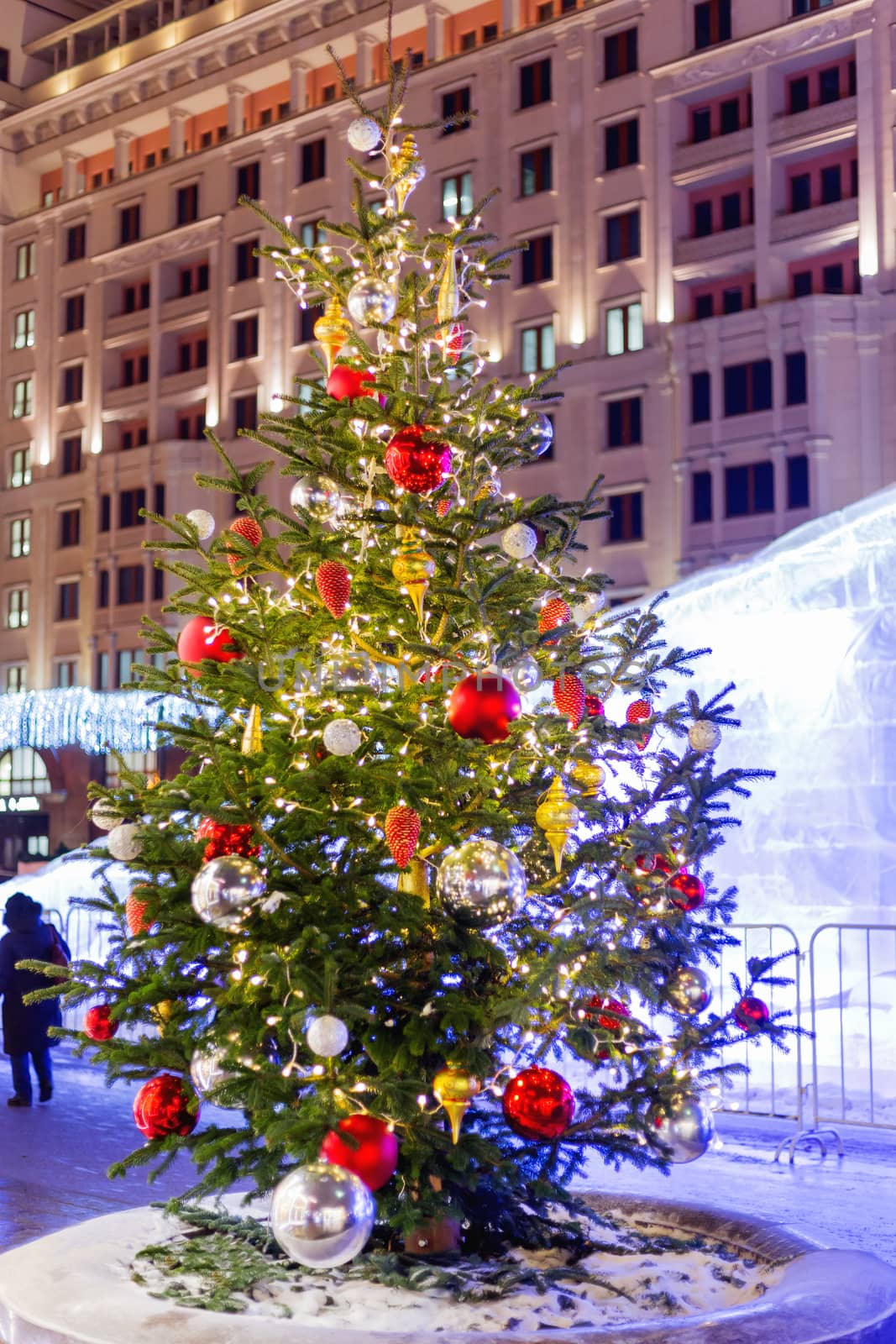 Streets in the historical center of Moscow decorated for New Year and Christmas celebration. Fir trees with bright red and yellow balls and light bulbs. Russia.