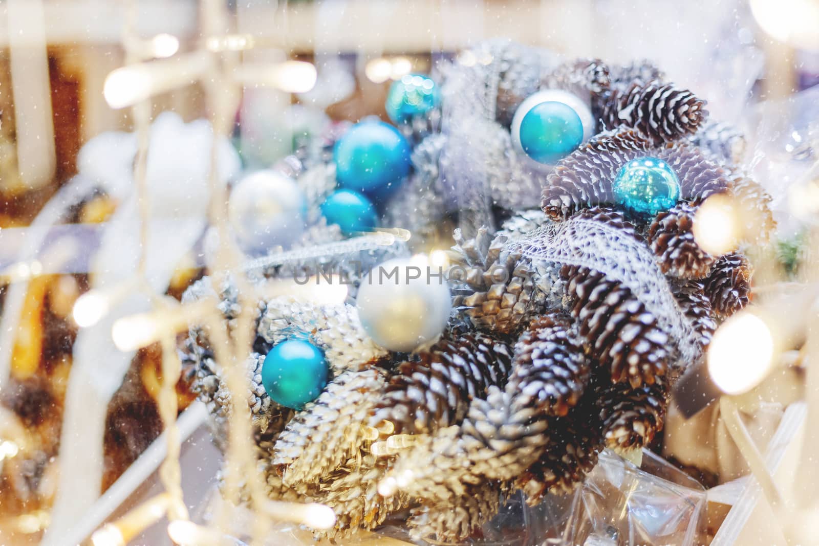 Christmas wreath made with pine and fir cones, bright blue balls. Hand made New Year decoration with light bulbs.