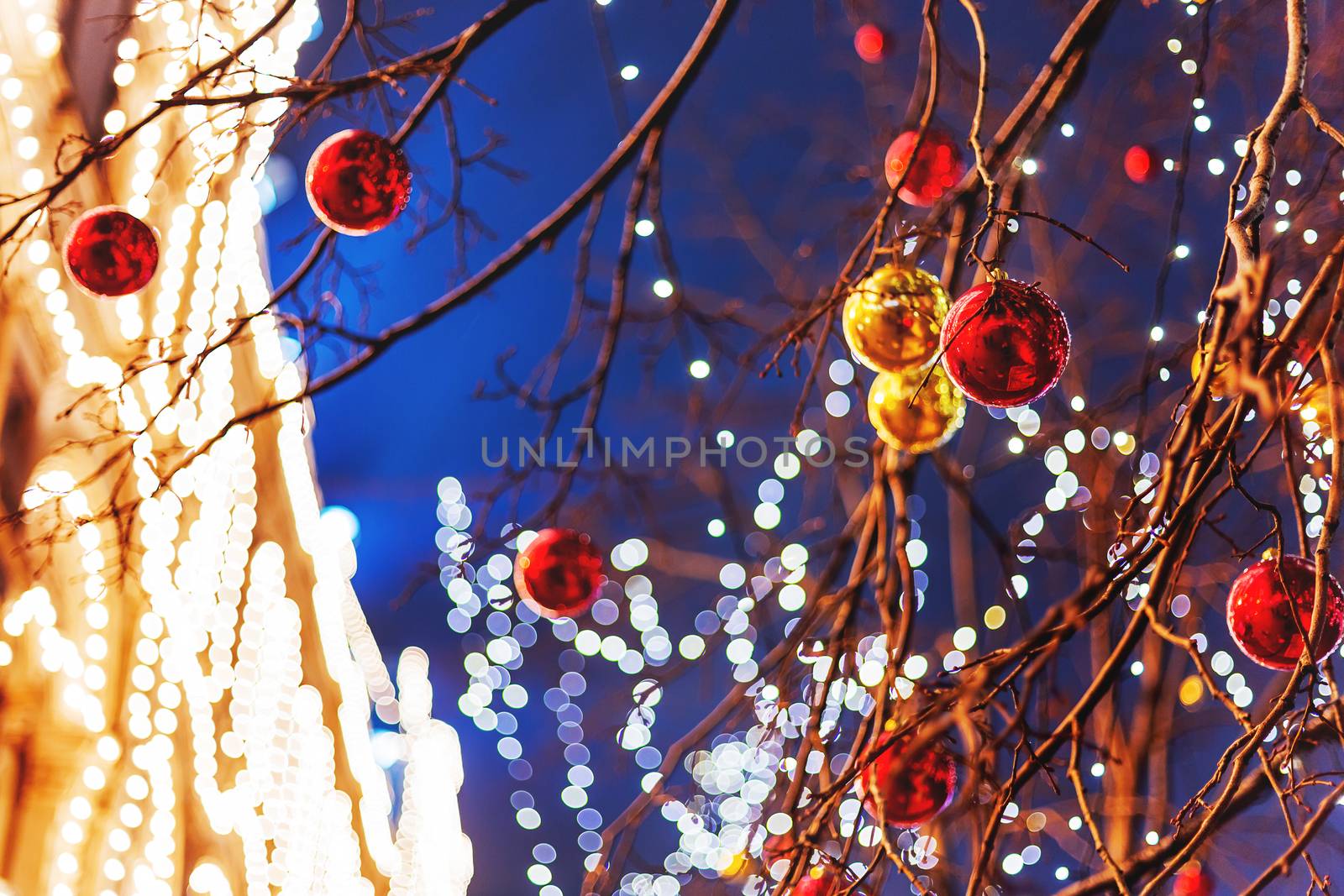 Streets of Moscow decorated for New Year and Christmas celebration. Tree with bright red and yellow balls. GUM (Main Department Store) building with light bulbs. Russia.