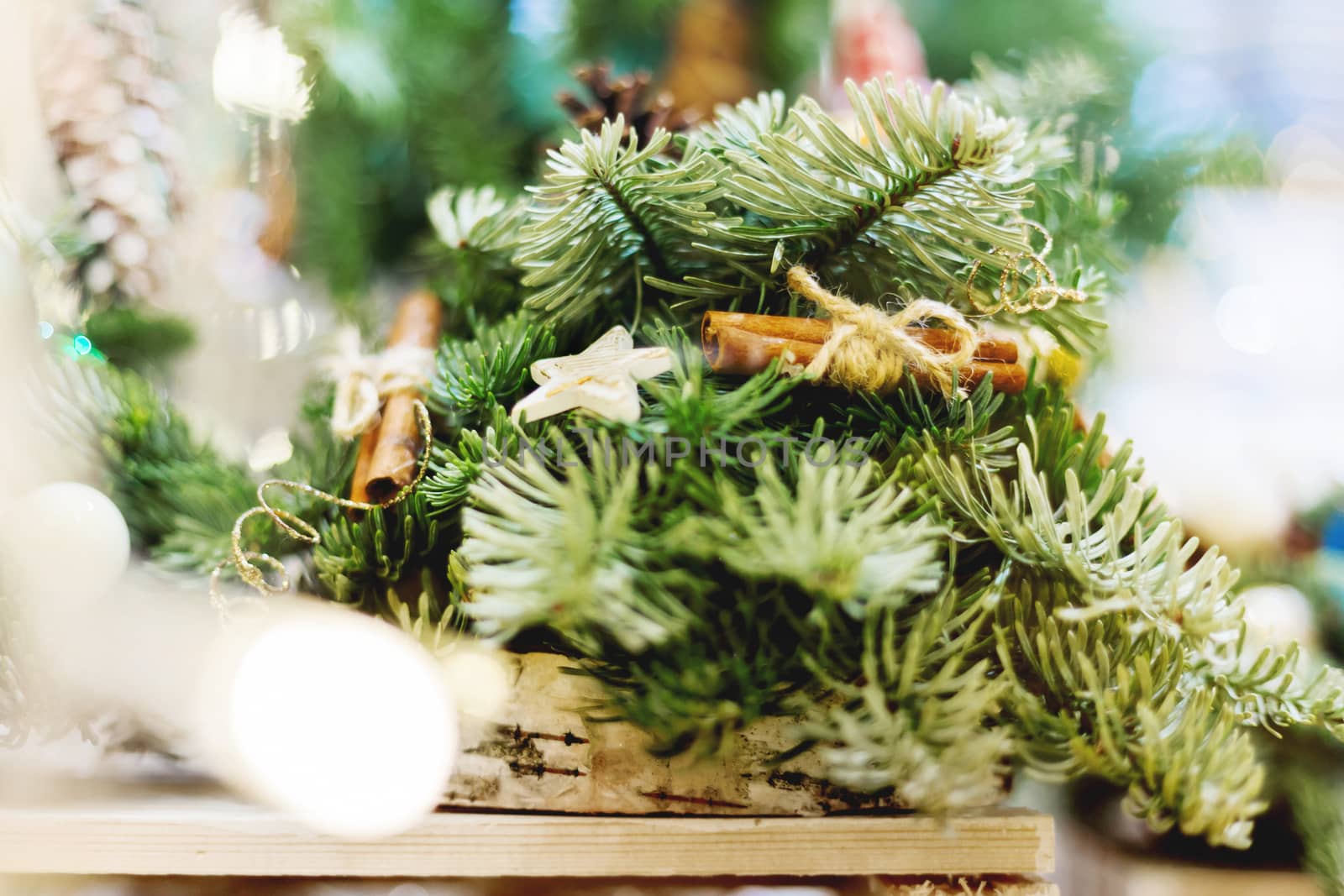Christmas wreath made with pine and fir branches, cinnamon and wooden stars. Hand made New Year decoration with light bulbs.