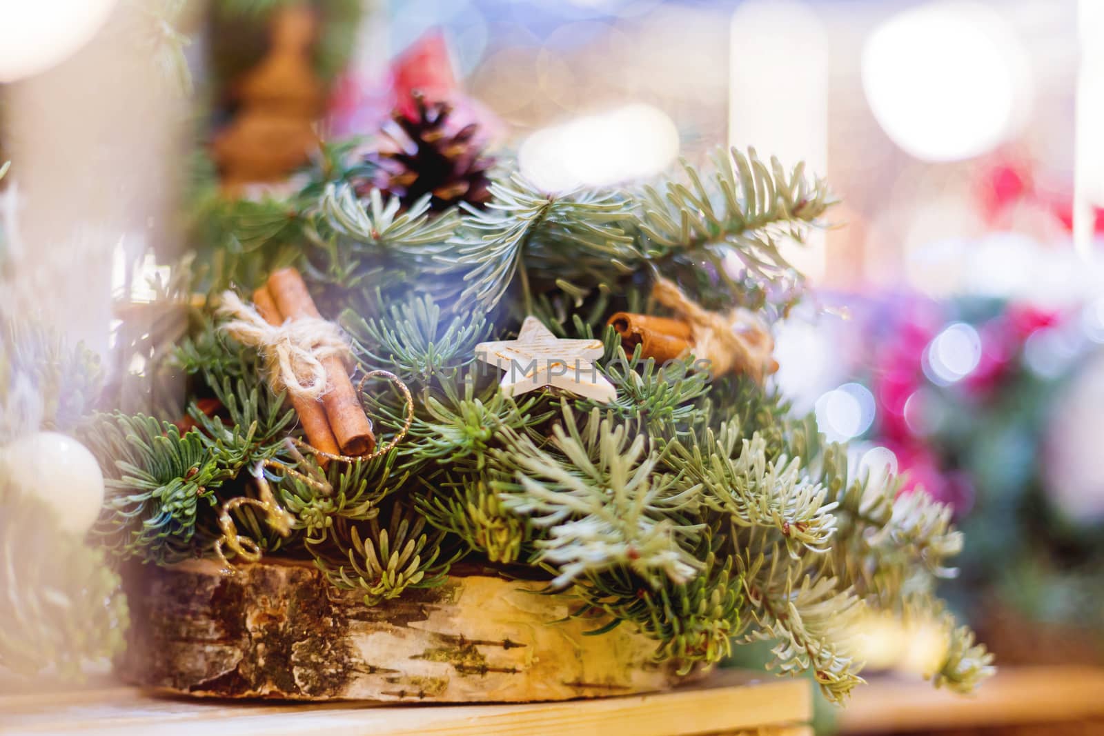 Christmas wreath made with pine and fir branches, cinnamon and wooden stars. Hand made New Year decoration with light bulbs.