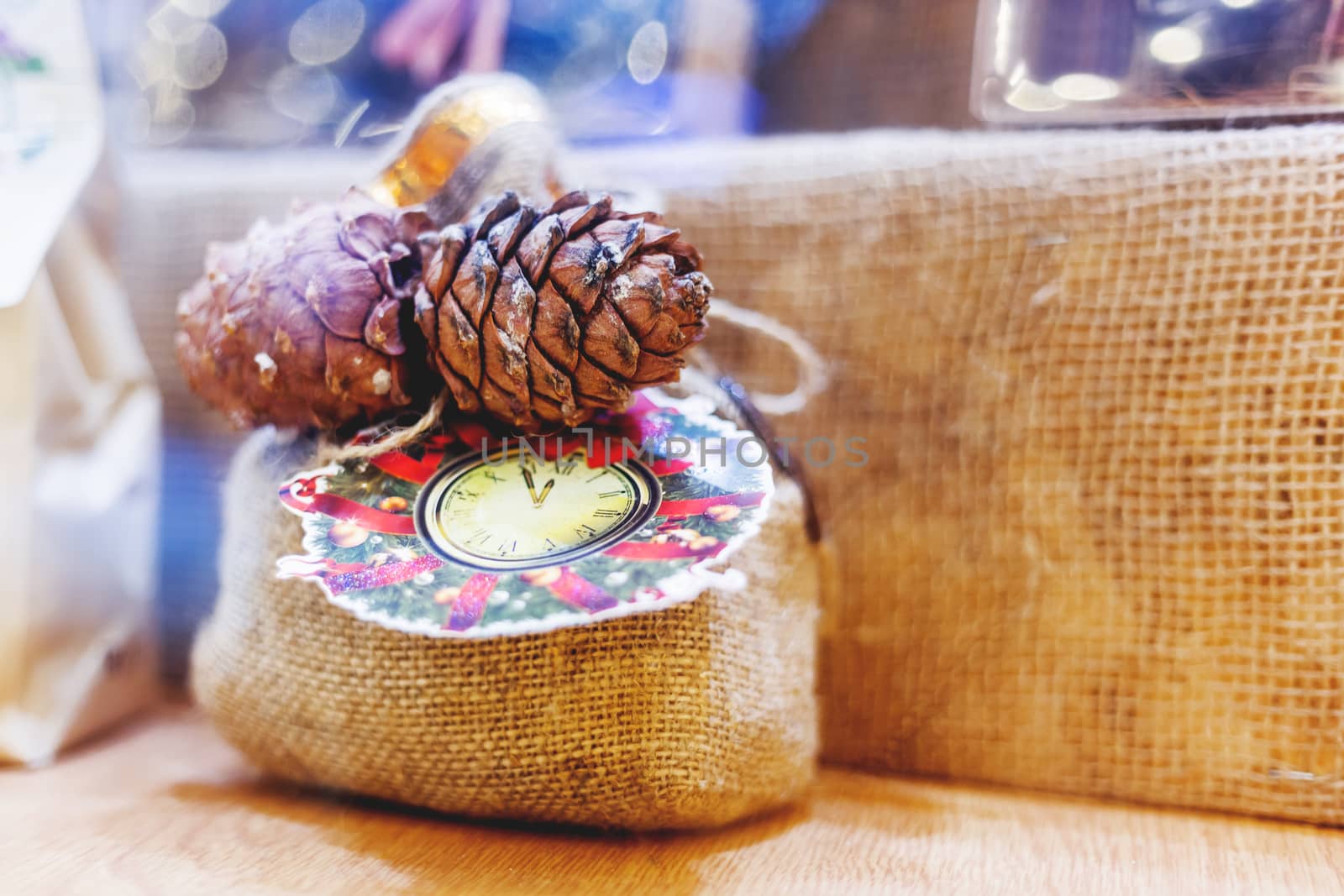 Christmas and New Year decoration - little bag made of burlap with pine cones and drawn clocks and wreath. Hand made present. Winter holiday gift.