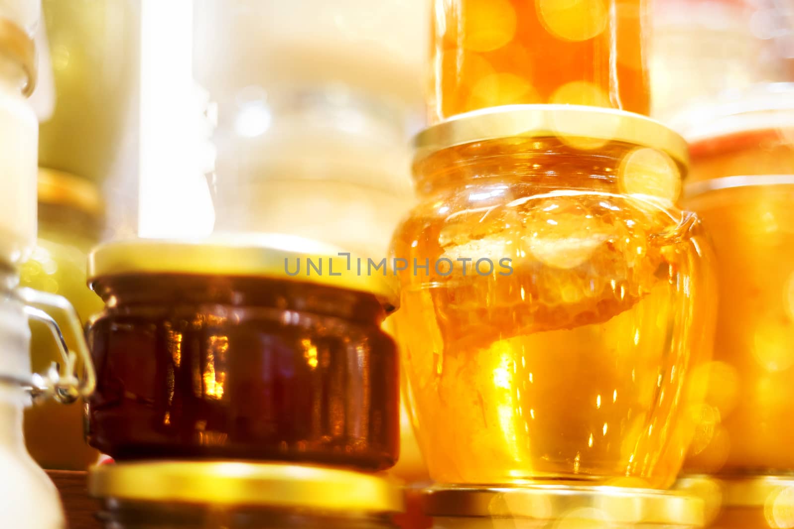 Holiday fair. Jars of honey glowing in garlands of lighting bulbs.