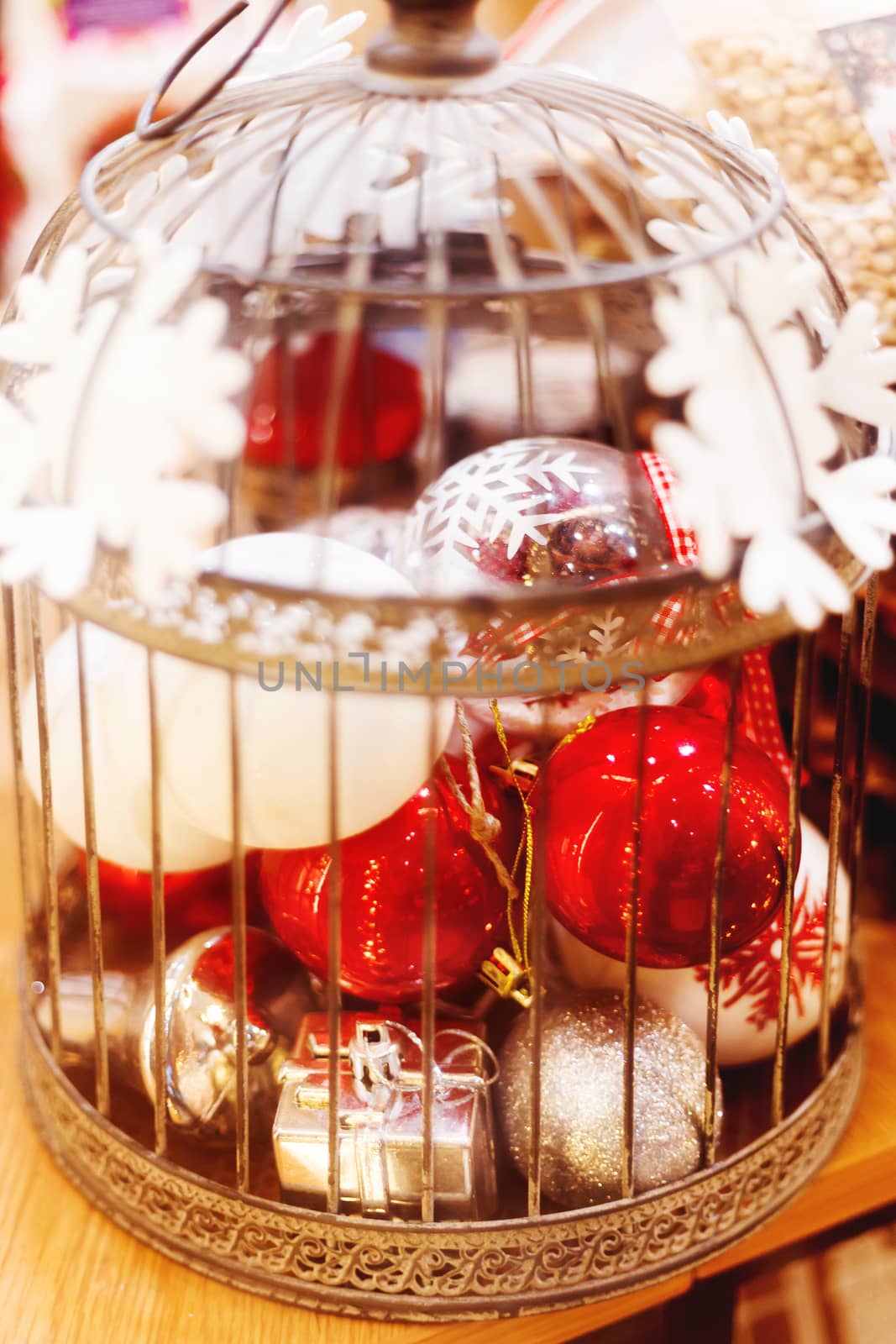 Christmas and New Year background with bright decorative balls in old fashioned ornamental bird cage. Decorations for holiday celebration.