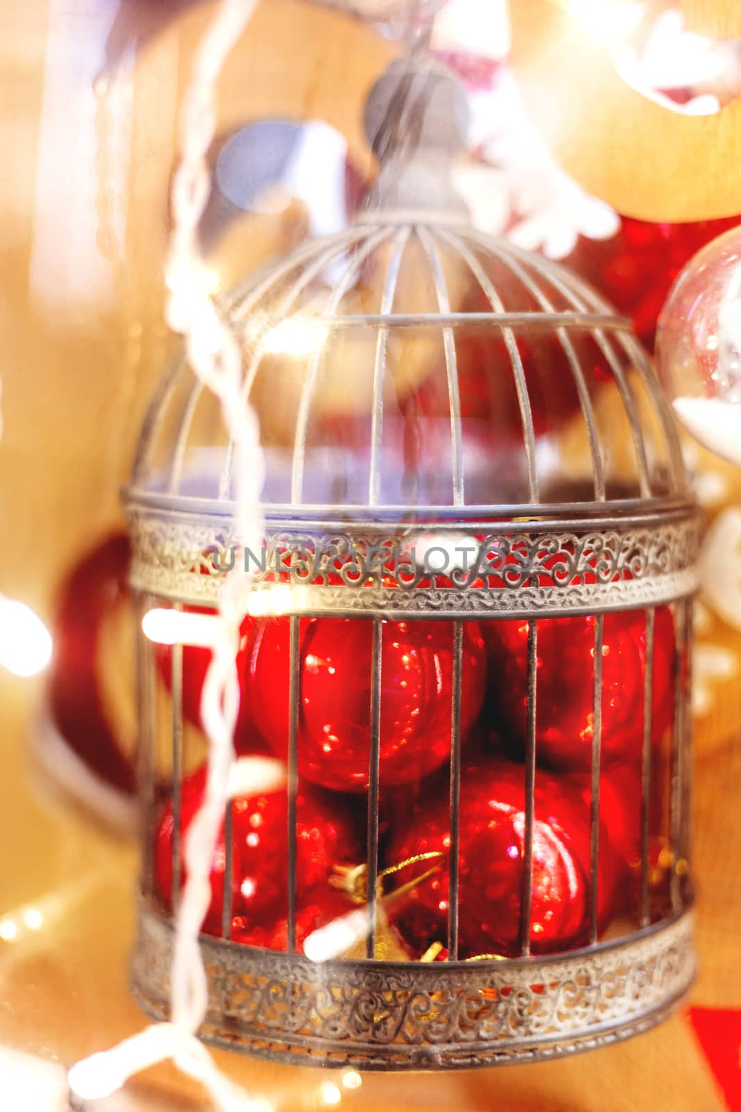 Christmas and New Year background with bright decorative balls in old fashioned ornamental bird cage. Decorations for holiday celebration.