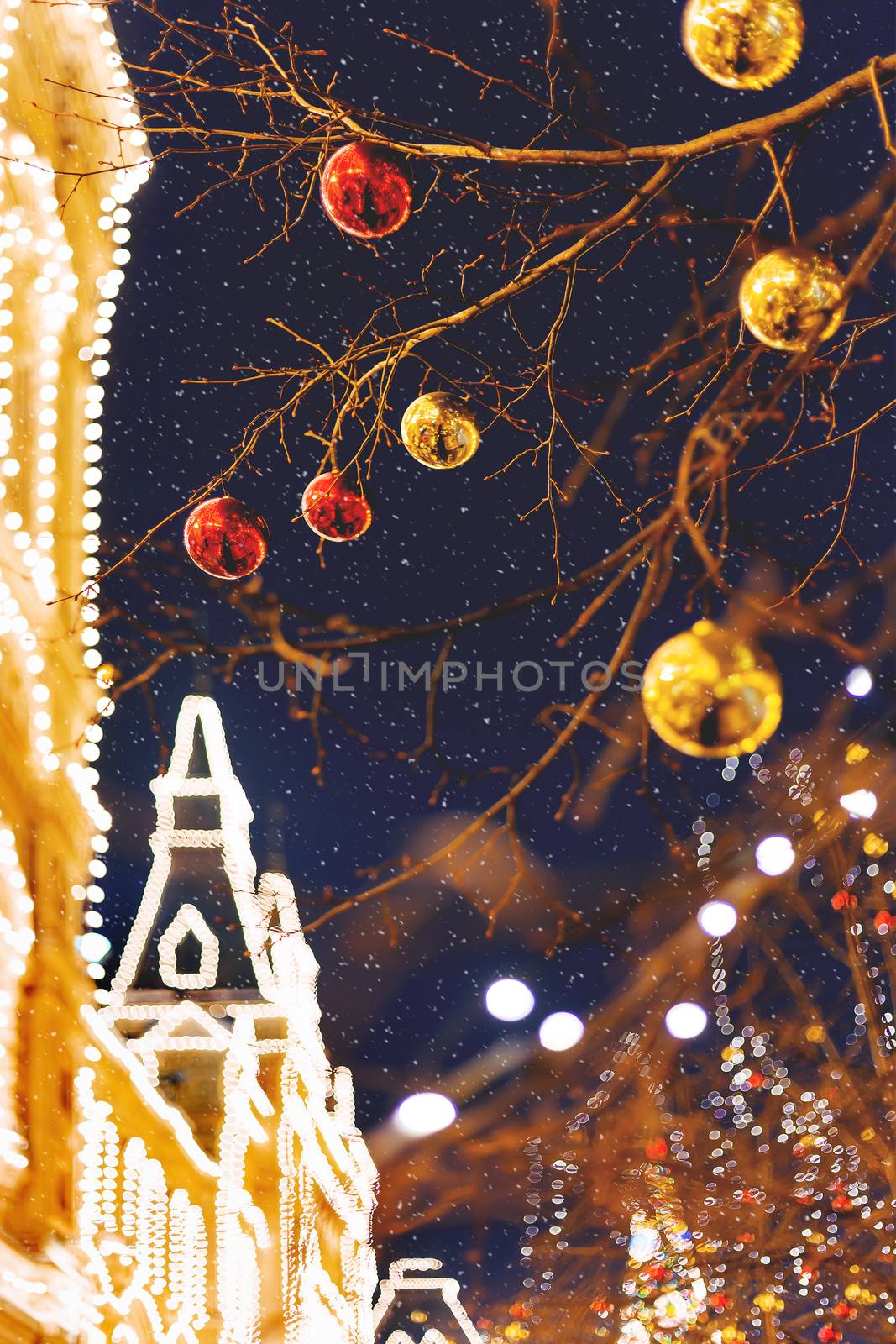 Streets of Moscow decorated for New Year and Christmas celebration. Tree with bright red and yellow balls. GUM (State Department Store) building with light bulbs. Russia. by aksenovko