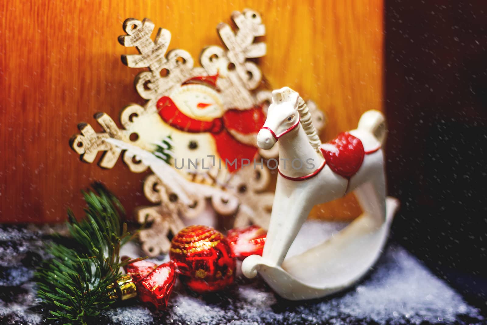 Christmas and New Year background with bright decorative ball and wooden rocking horse toy. Decorations for holiday celebration.