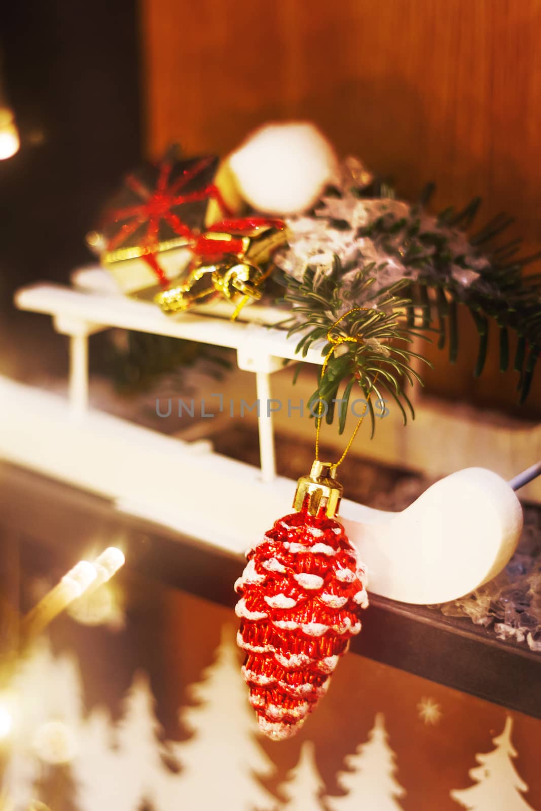 Christmas and New Year decorations - white wooden sledge with bright sparkling pine cone and fir tree branches.