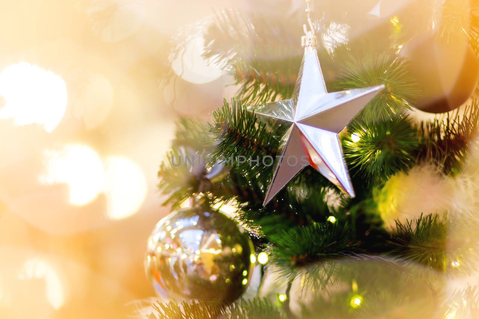 Fir tree decorated with shiny balls, star and light bulbs for Christmas and New Year celebration.
