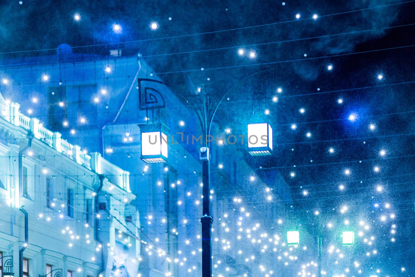 Blizzard rages around street lantern. Strong wind and snow on streets of Moscow, decorated to celebrate the New year and Christmas. Russia.