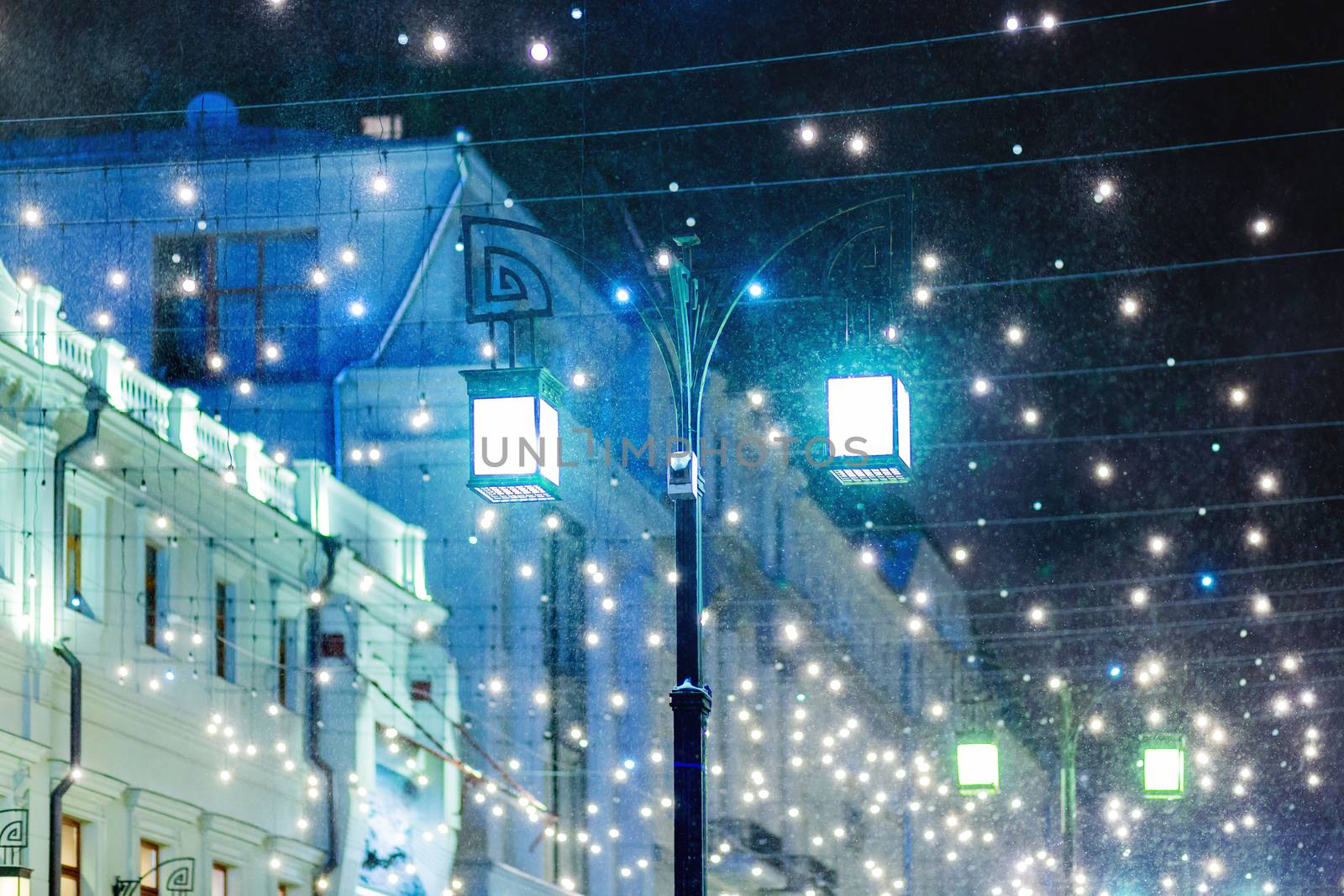 Blizzard rages around street lantern. Strong wind and snow on streets of Moscow, decorated to celebrate the New year and Christmas. Russia.
