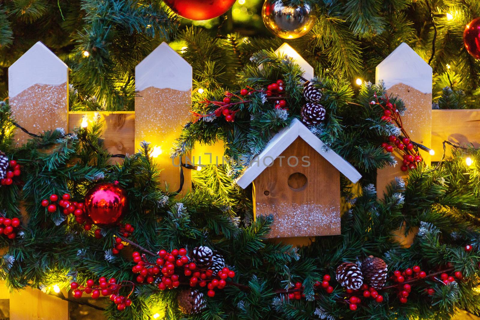 Christmas and New Year outdoor decorations - bird house with traditional fir tree wreaths.