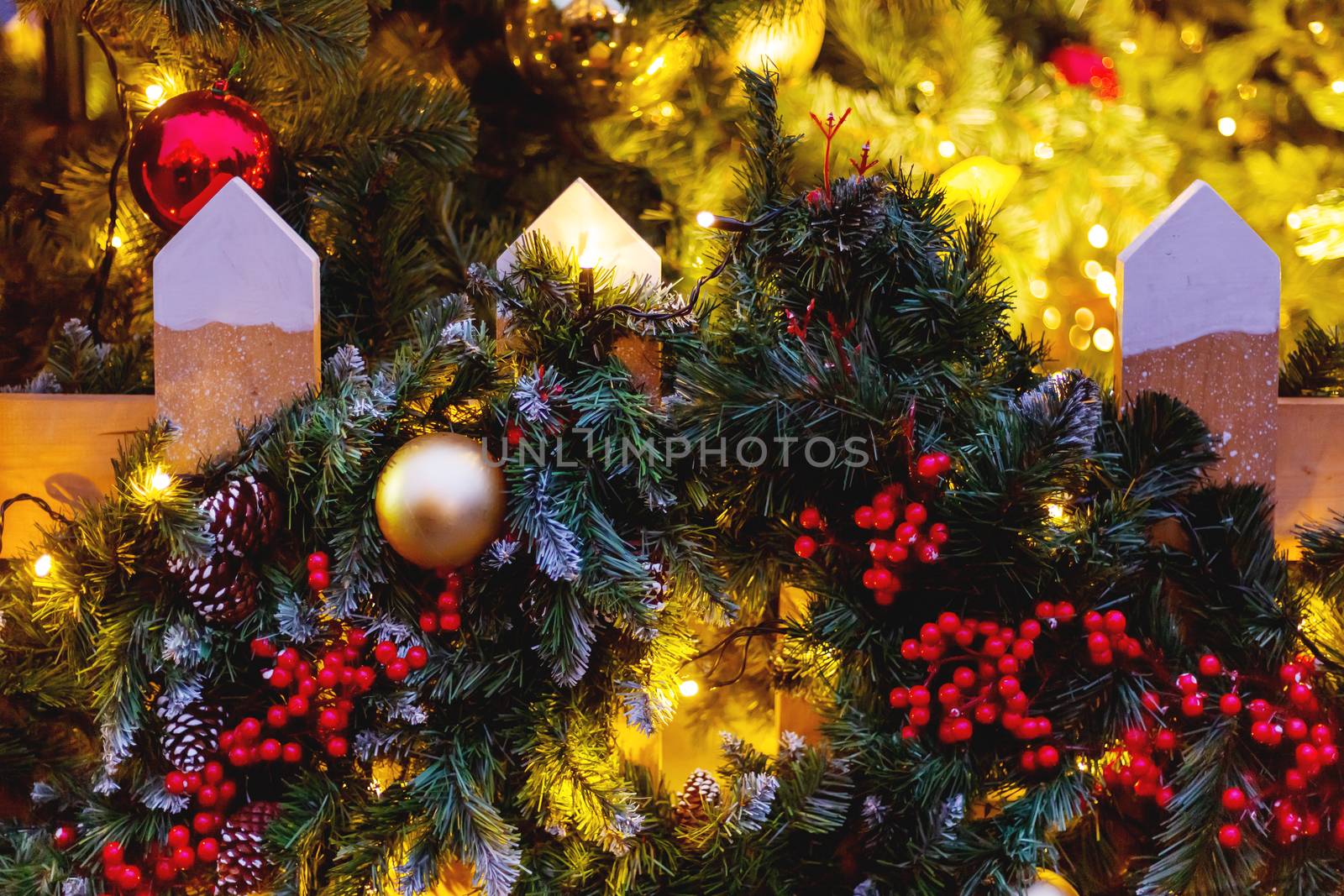 Christmas and New Year outdoor decorations - traditional fir tree wreaths with balls and berries on fence.