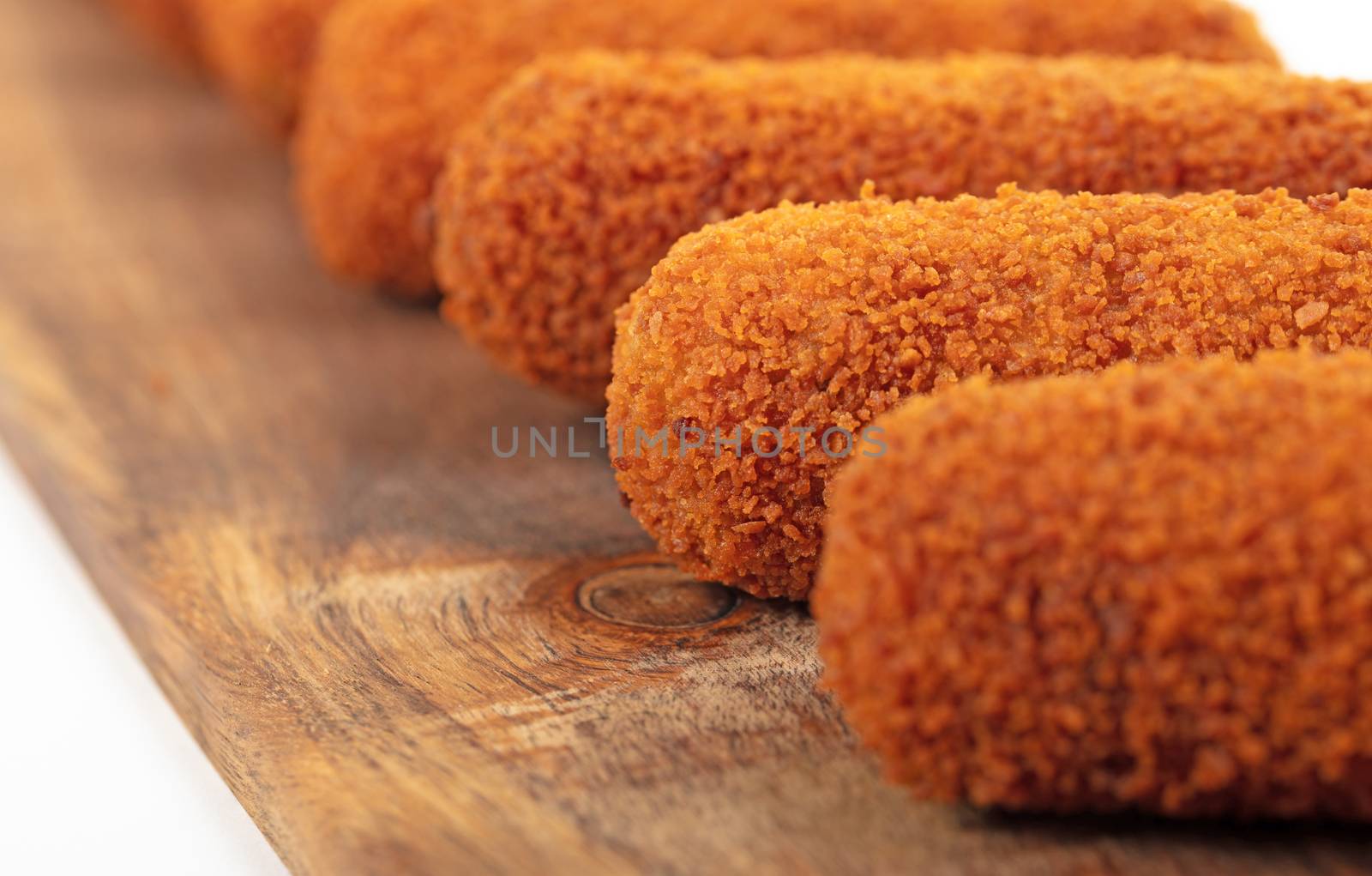 Brown crusty dutch kroketten on a serving tray, selective focus, isolated