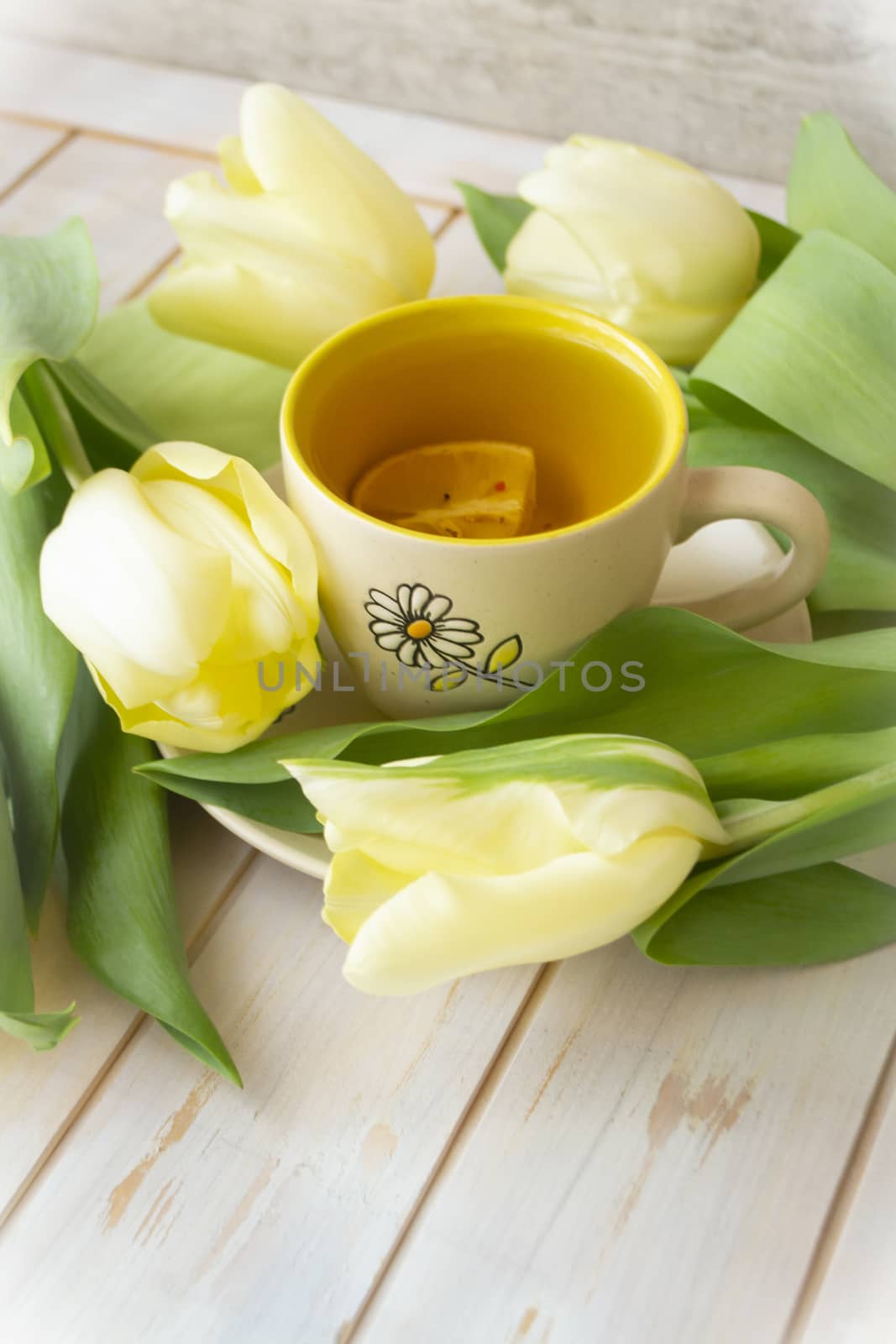 A mug with tea with yellow tulips. Women, mother, valentines day greeting card, vertical image