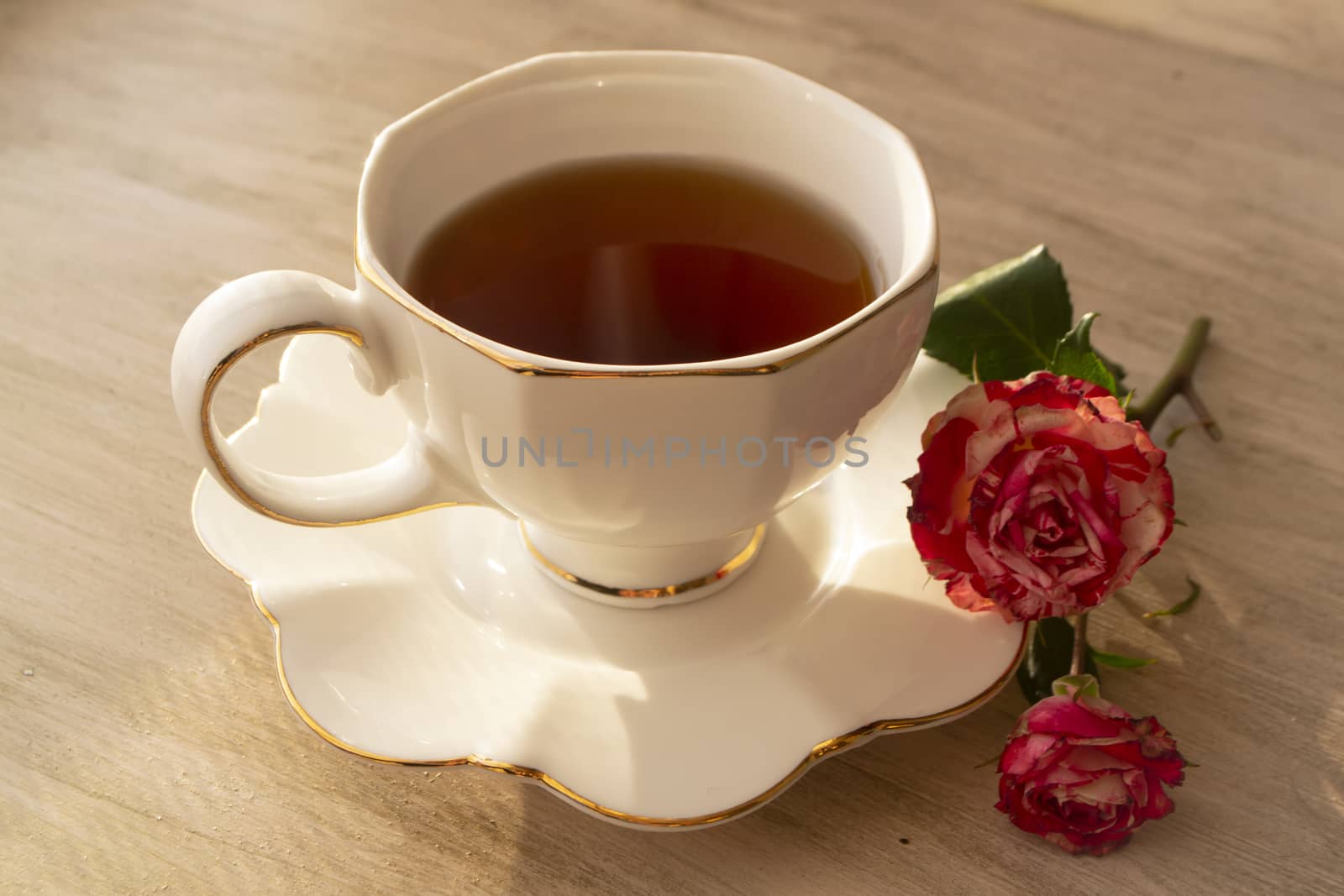 Healthy tea in white classic cup with roses, vintage