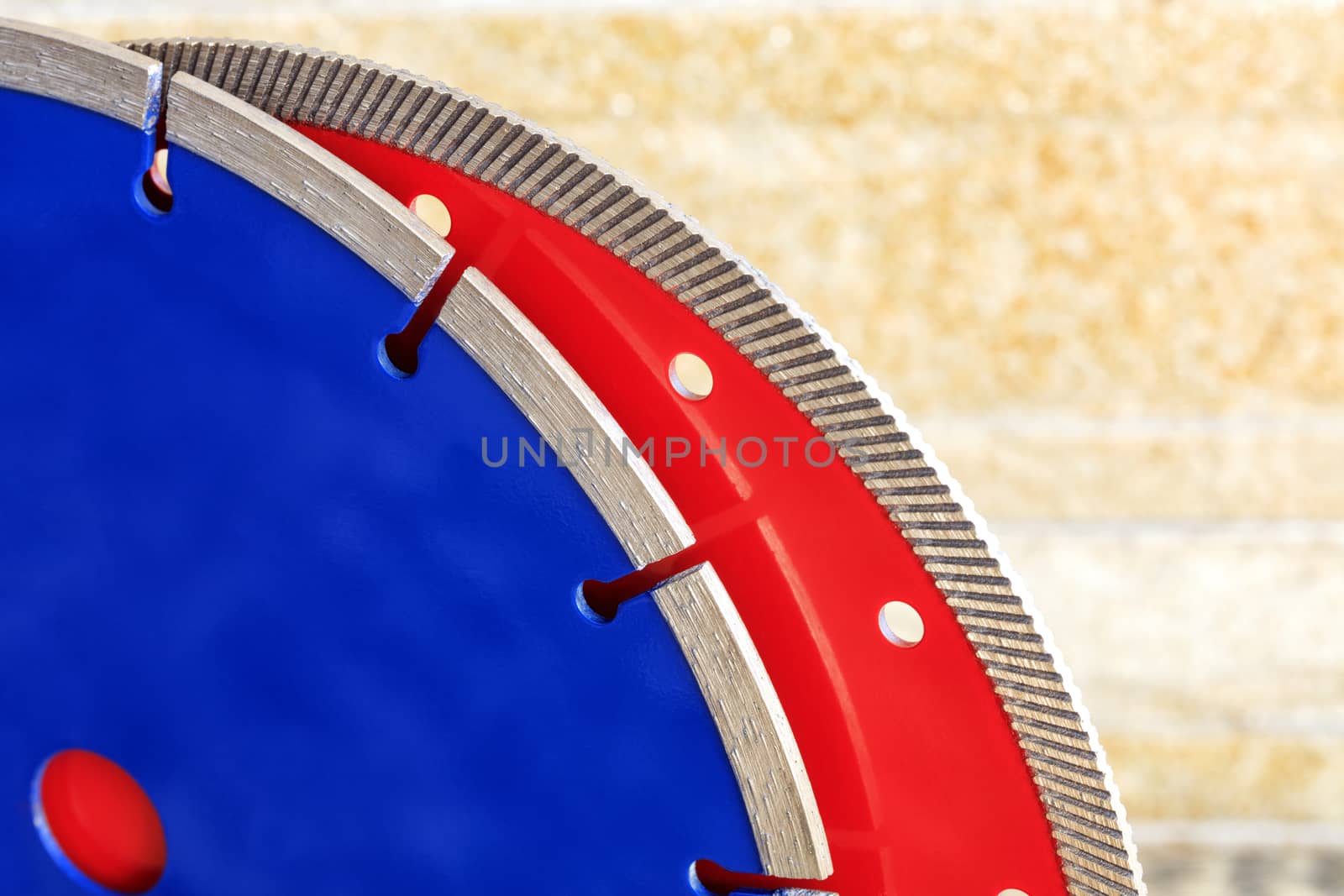 Diamond blades for granite and reinforced concrete against a background of orange-gold sandstone walls. by Sergii