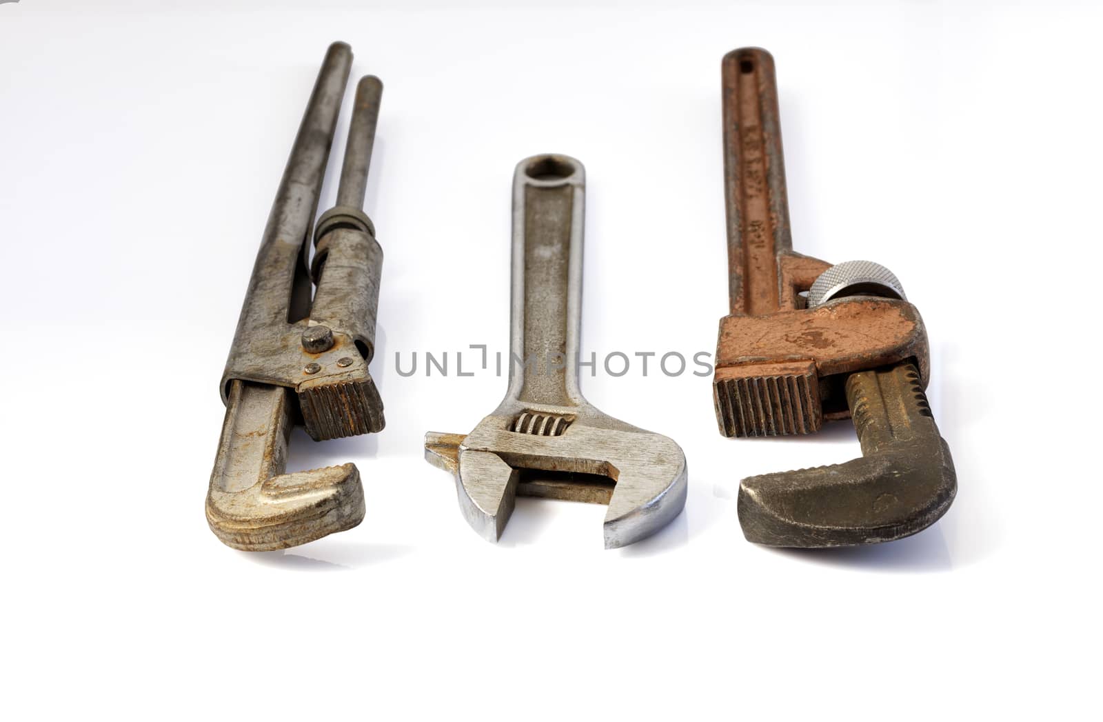 Old metal adjustable pipe wrenches horizontal and isolated on white background closeup.