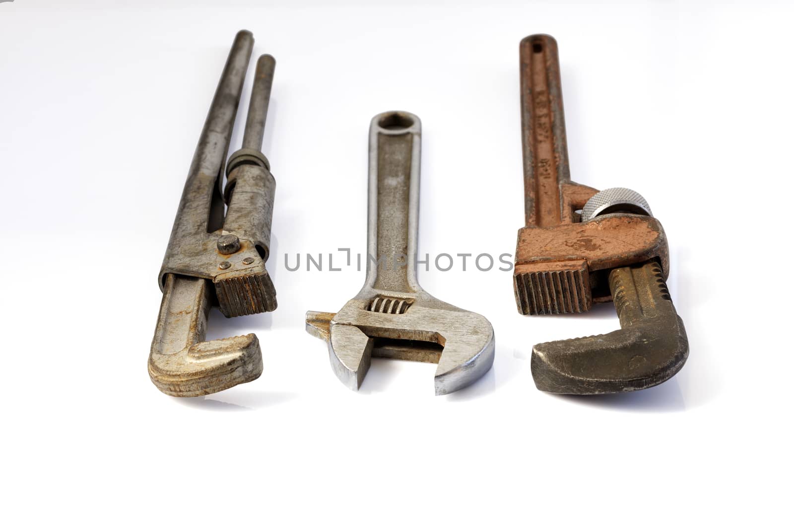 Old metal adjustable pipe wrenches horizontal and isolated on white background closeup.