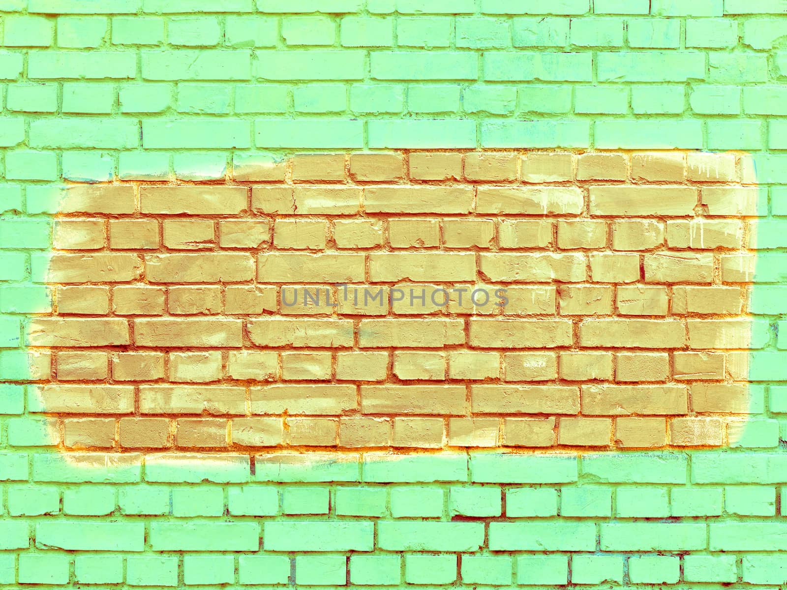 On the old bright green lime brick wall the selected fragment is painted with orange paint. by Sergii