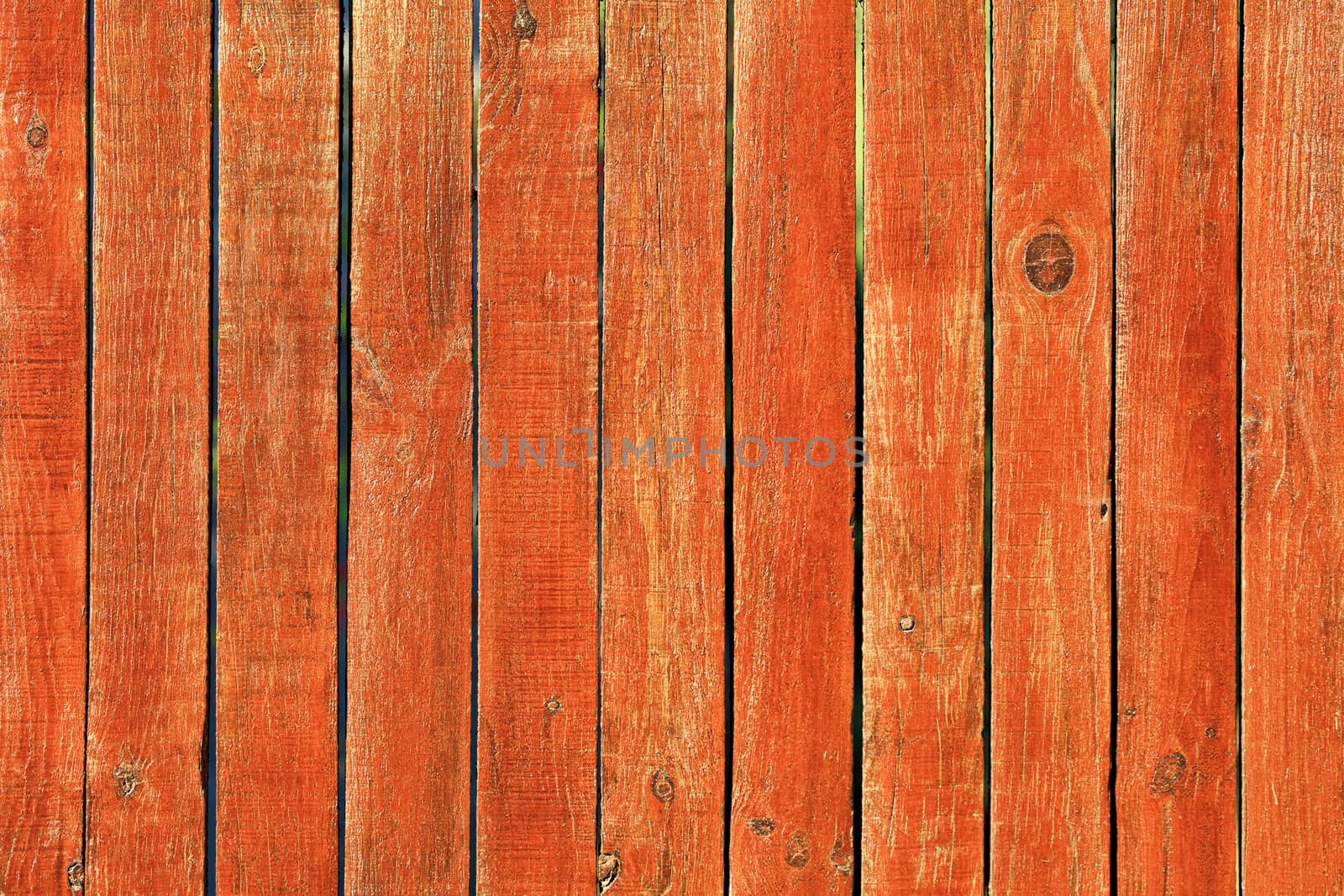 Shabby orange paint on an old wooden fence and wood texture.