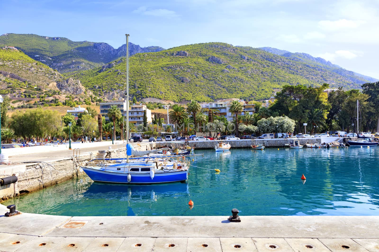 View of the pier of the bay, where old fishing schooners, boats and boats are moored in the clear waters of the Ionian Sea. by Sergii