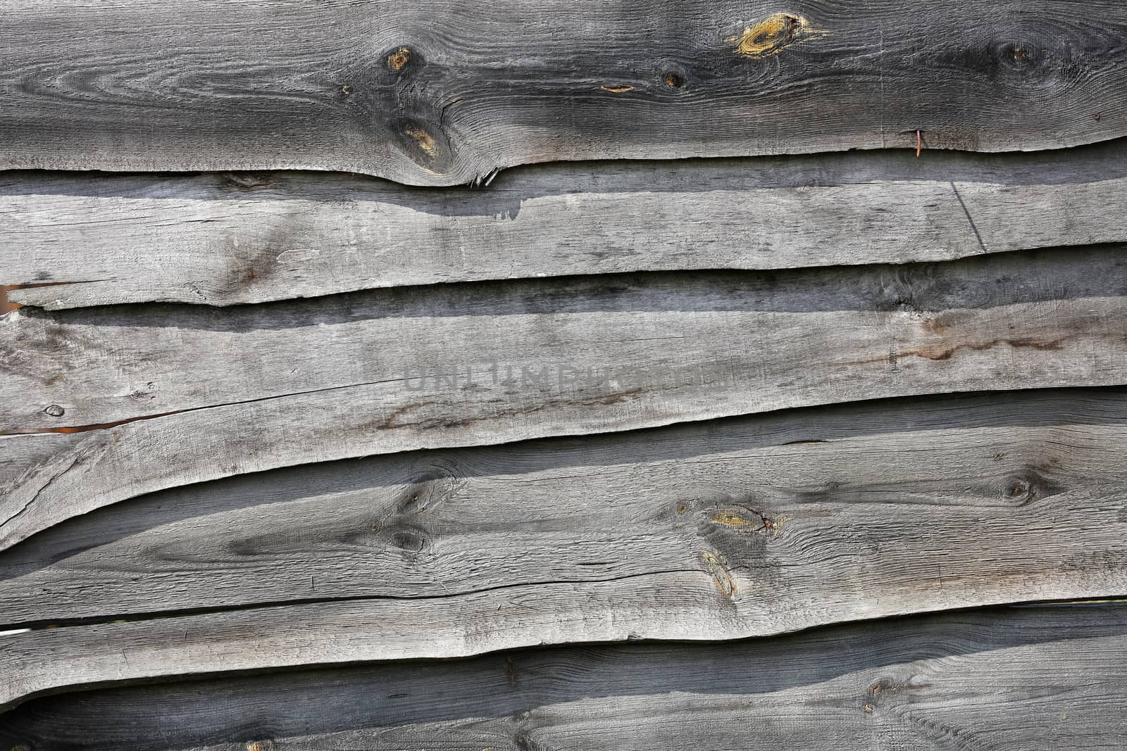 A wooden fence made of weathered old gray boards. by Sergii