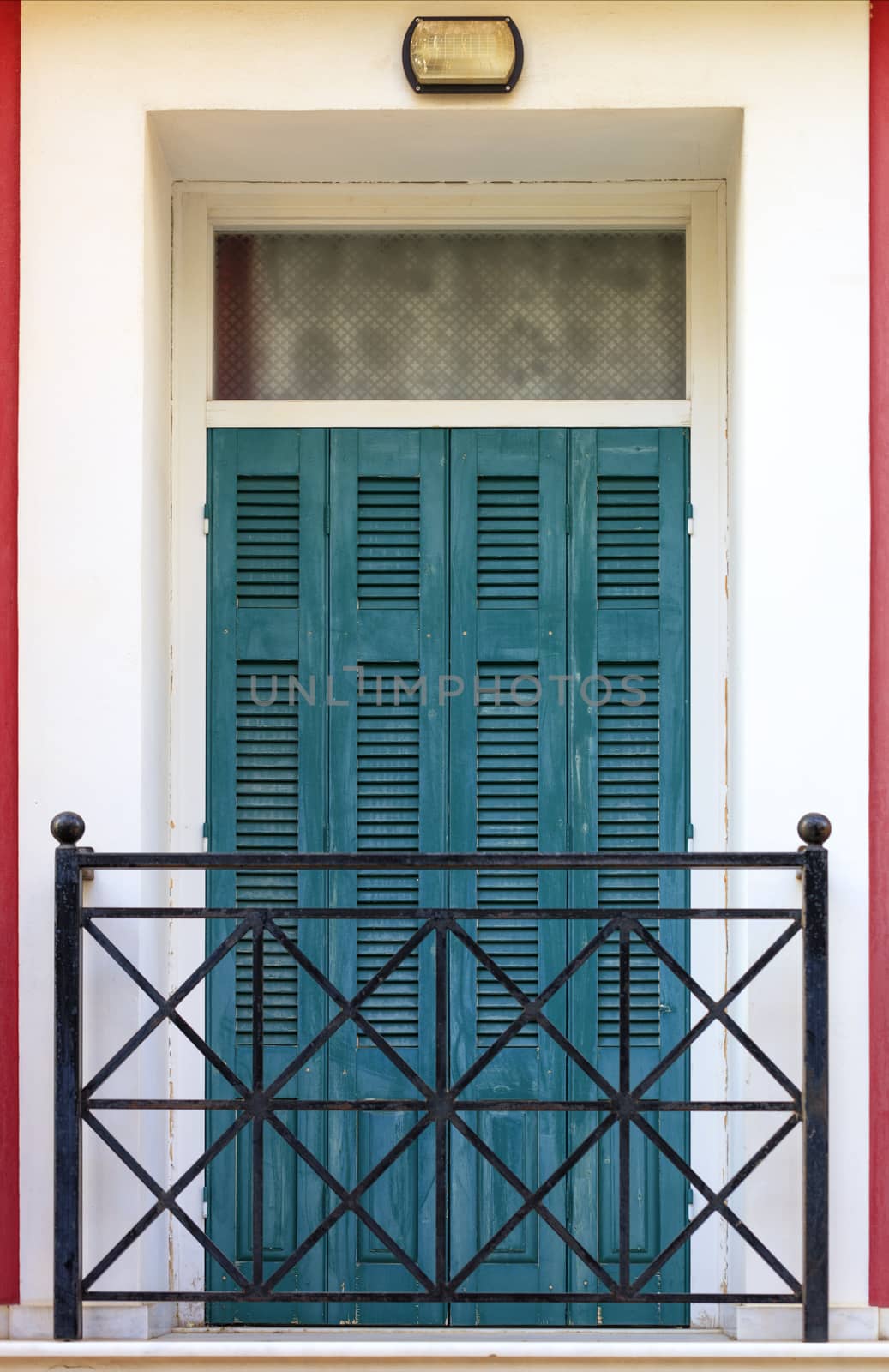 Old green wooden balcony doors with wooden shutters and metal bars in the Greek style balcony. by Sergii