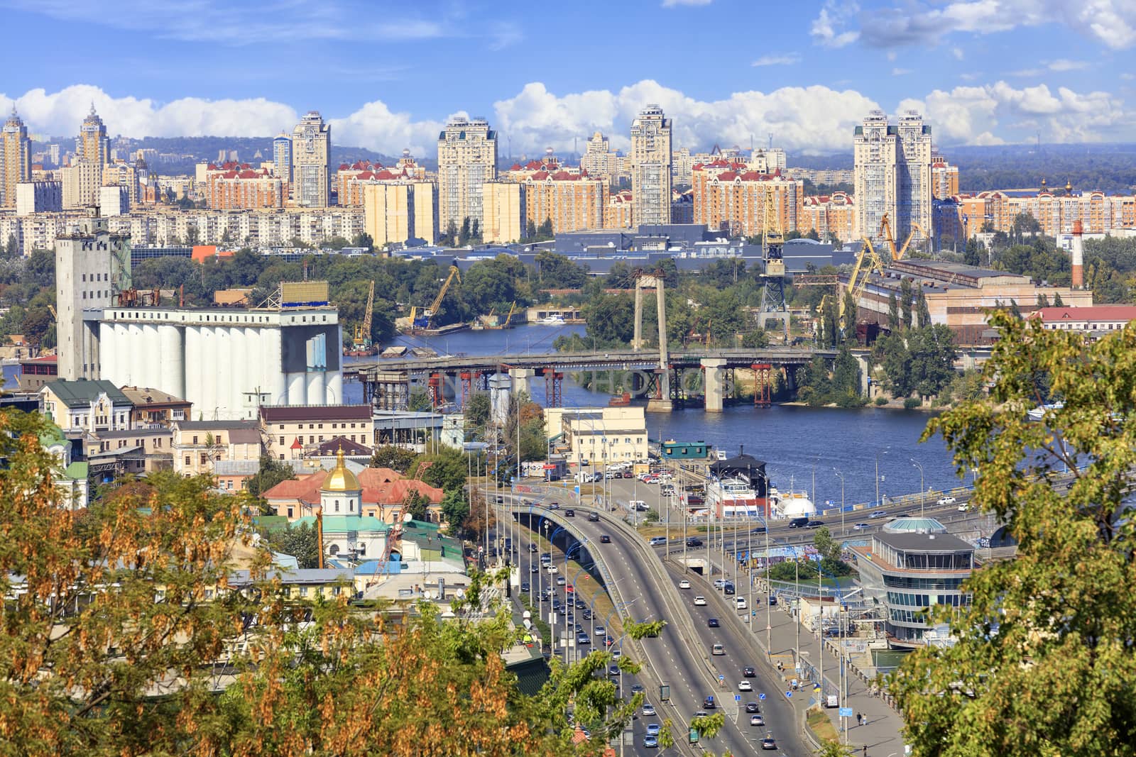 The landscape of the autumn city of Kyiv with a view of the Dnipro River, many bridges, the old Podilsky district and new houses on Obolon. by Sergii