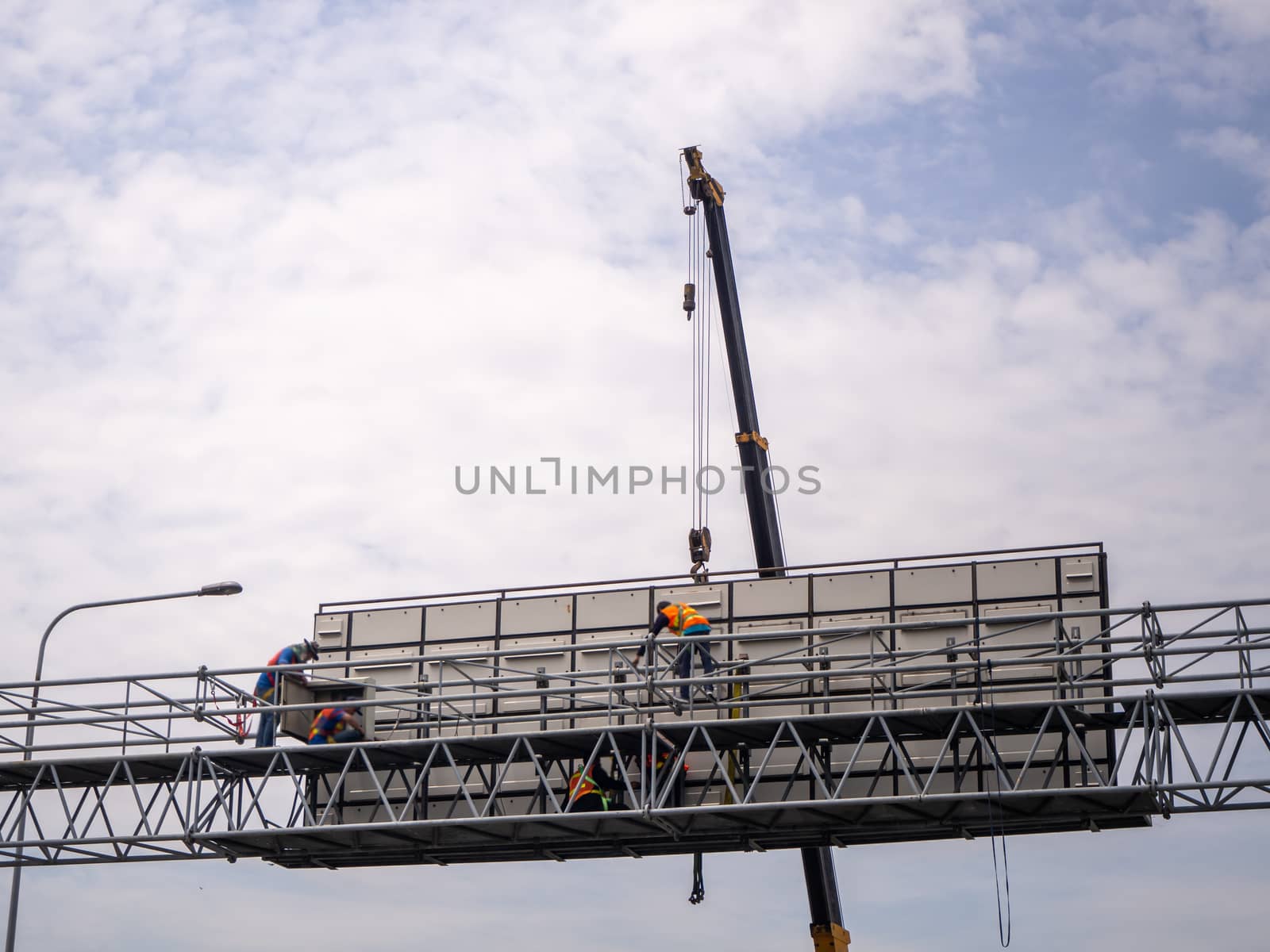 Construction site crane is lifting a led signboard Blank billboard on blue sky background for new advertisement