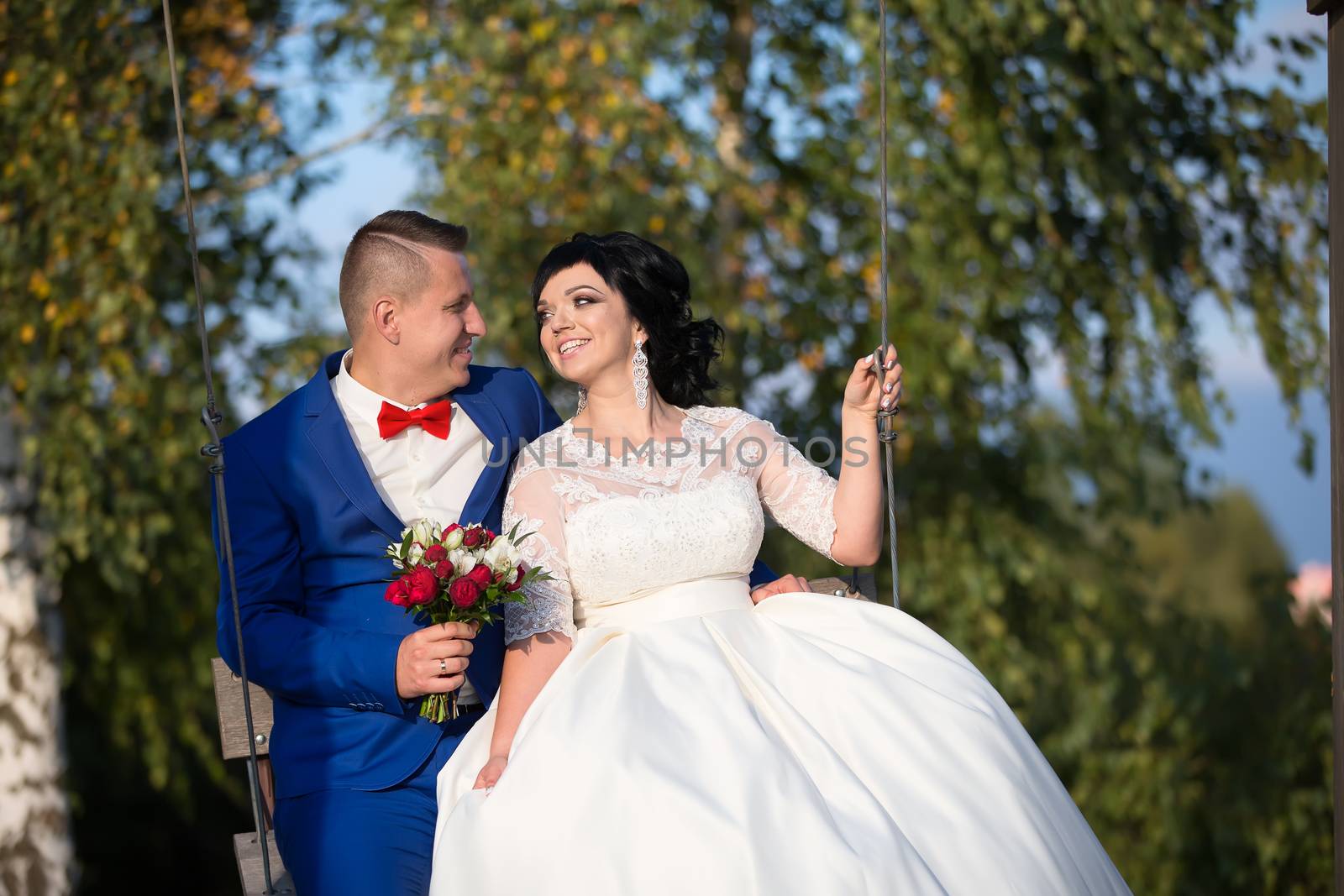 The bride and groom on the swing.The bride and groom on a walk