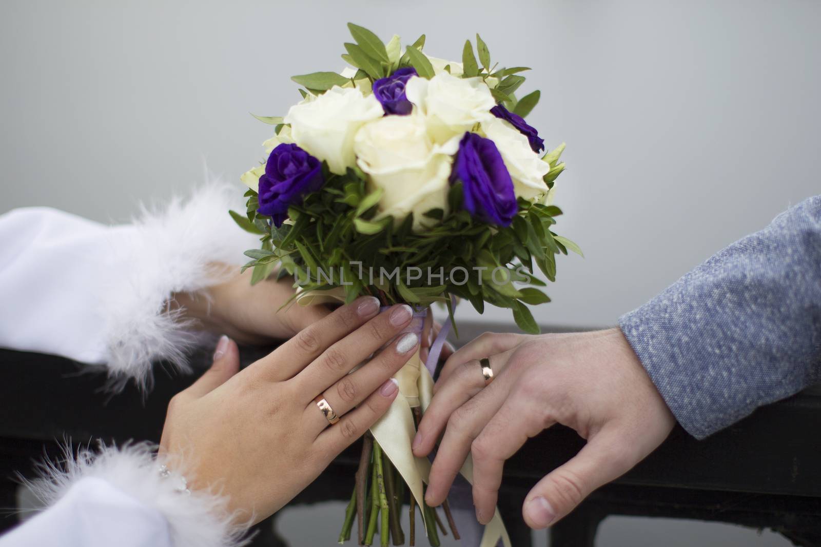 Bridal bouquet and hands with wedding rings. The bride's bouquet. Wedding rings.